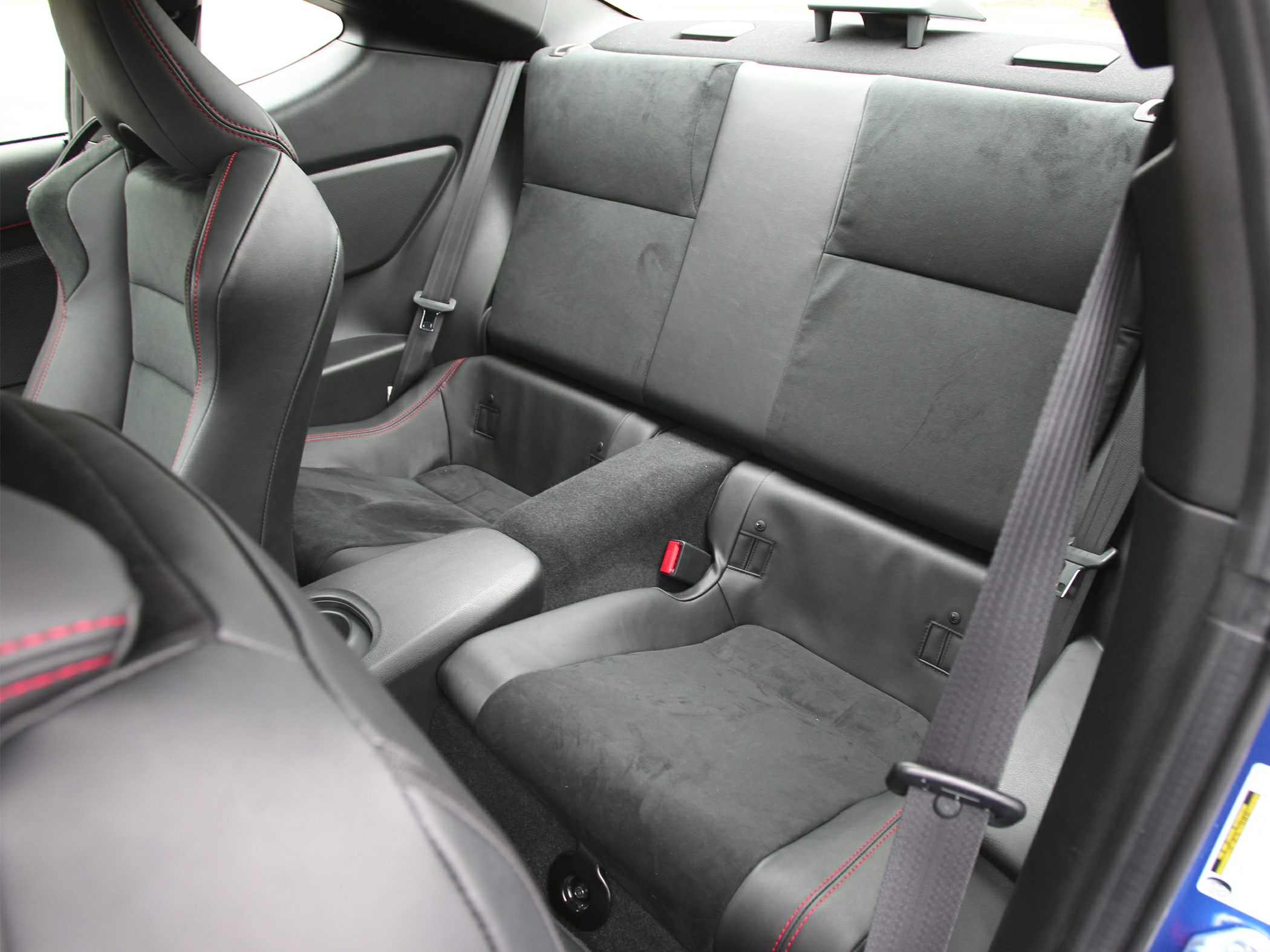 Rear seating area with black Alcantara upholstery and red stitching