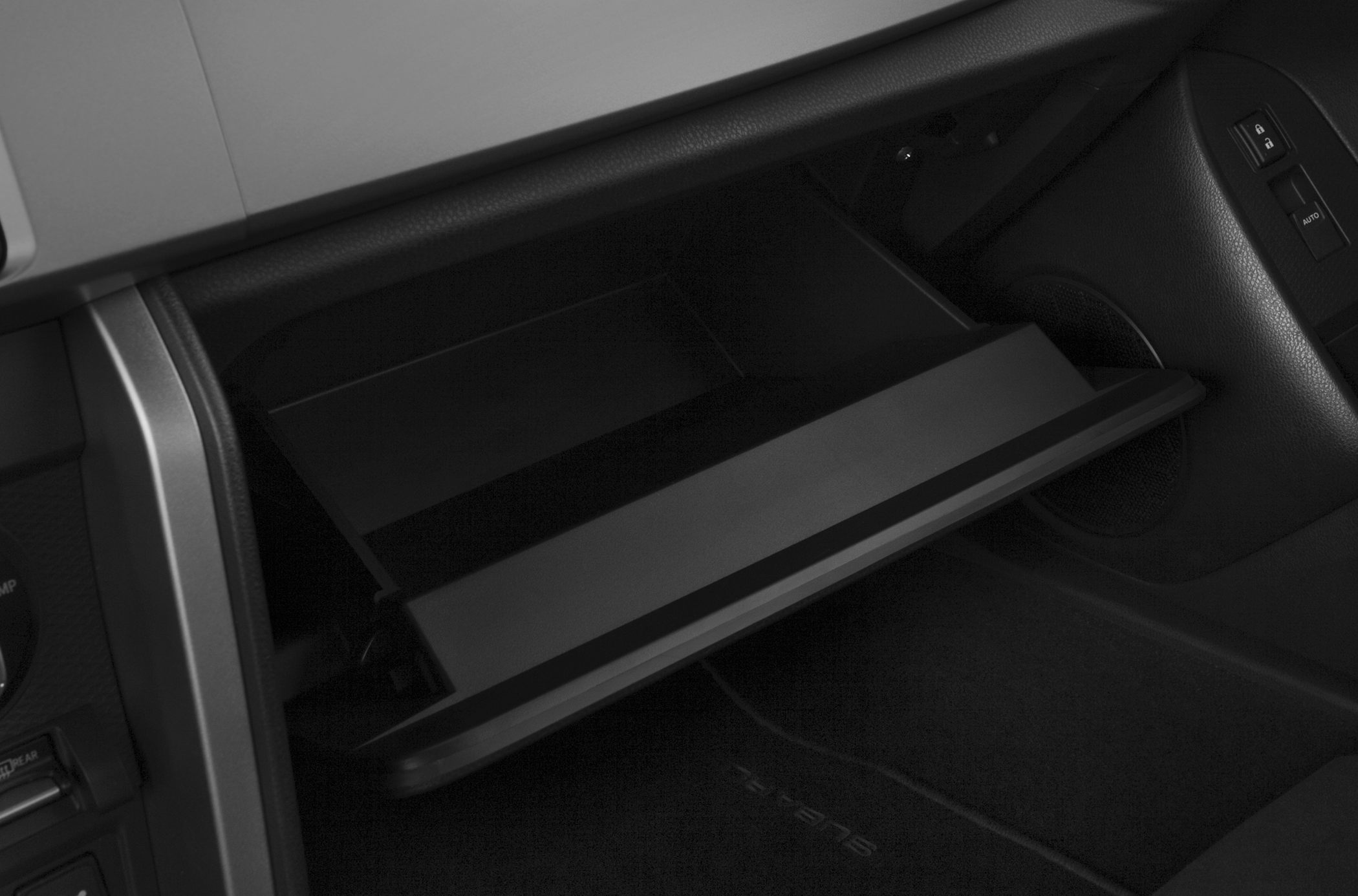 Open car glove compartment inside vehicle interior.