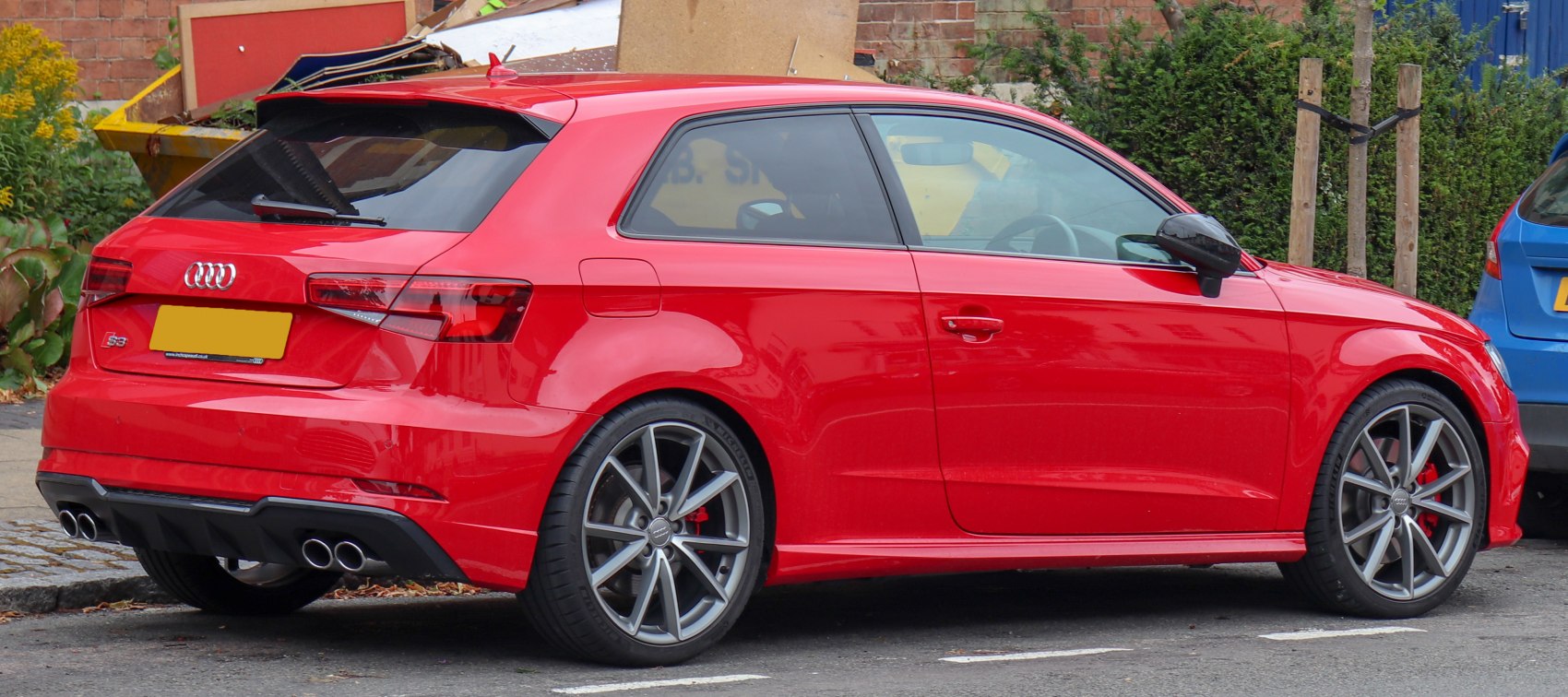Rear side view of a sporty hatchback with quad exhaust and alloy wheels