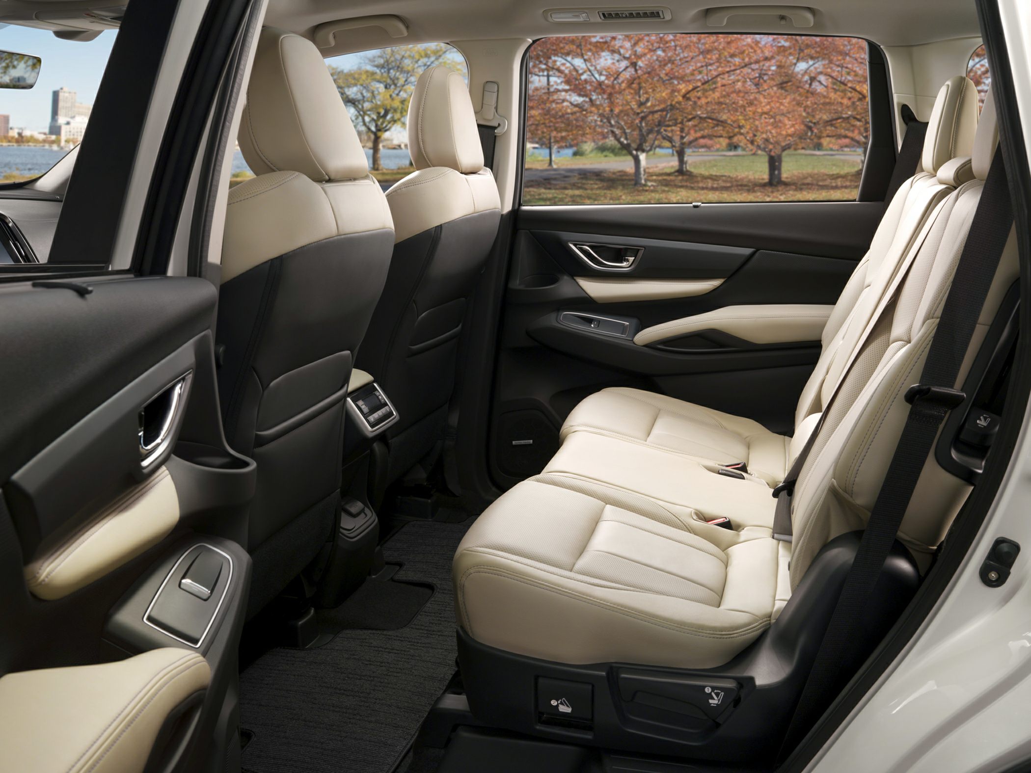 Spacious beige leather rear passenger seats with door panel and window.