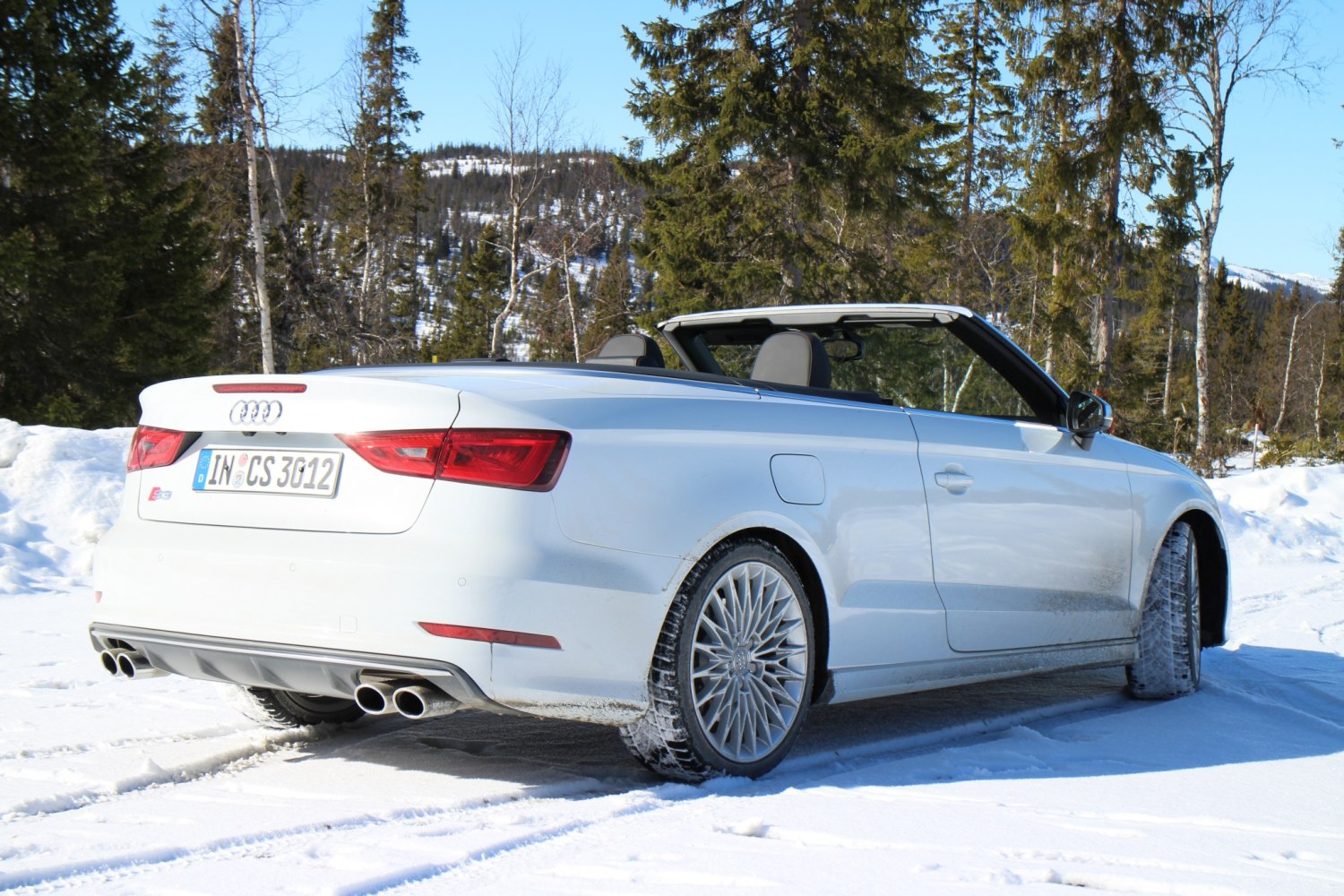 Convertible rear and side view with quad exhaust and alloy wheels on snow