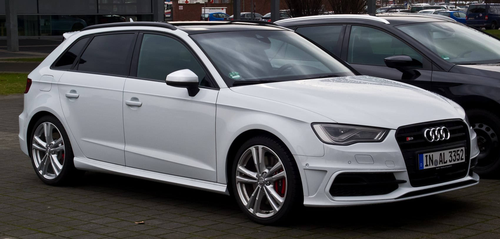 White sporty hatchback with alloy wheels and aggressive front design