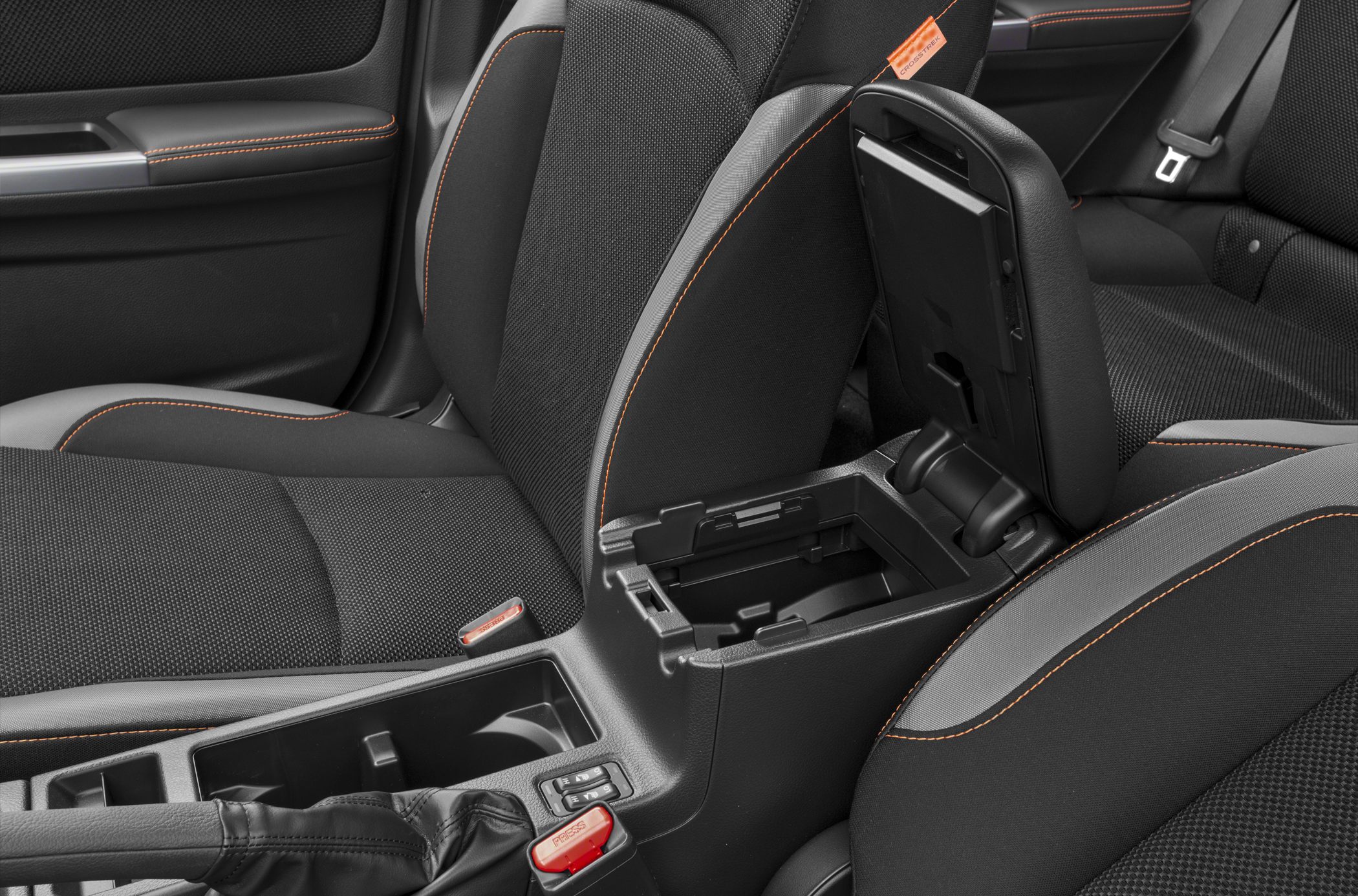 Car interior with orange stitched seats and open center console storage