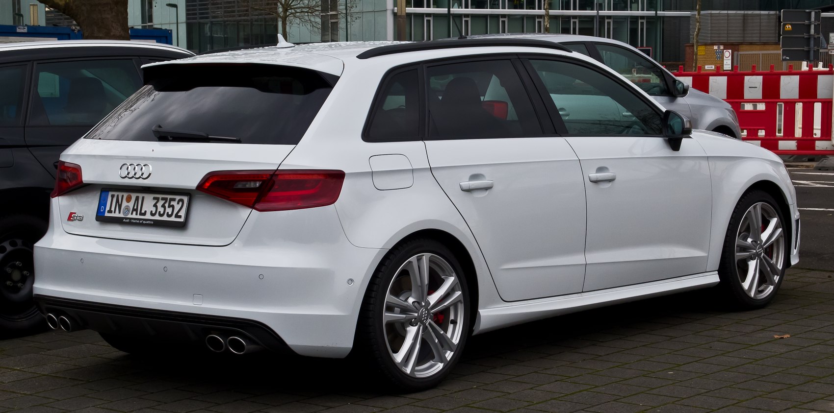 Rear side view of a white hatchback with quad exhaust and alloy wheels