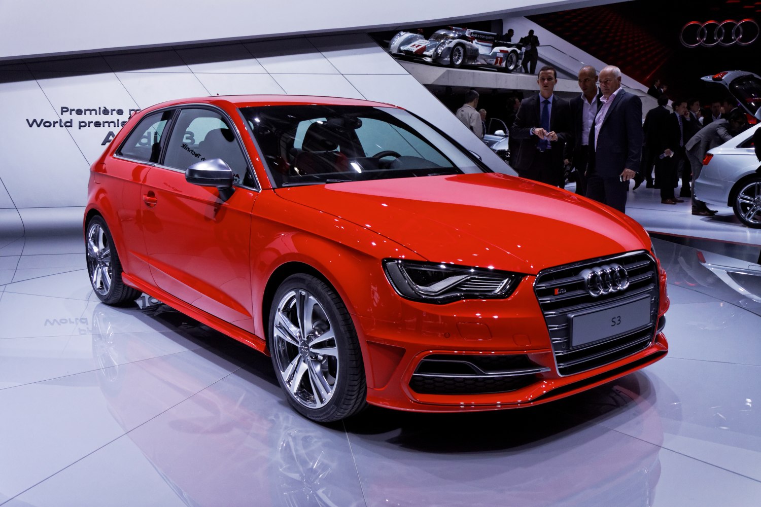 Front-side view of a red hatchback with sporty headlights and alloy wheels