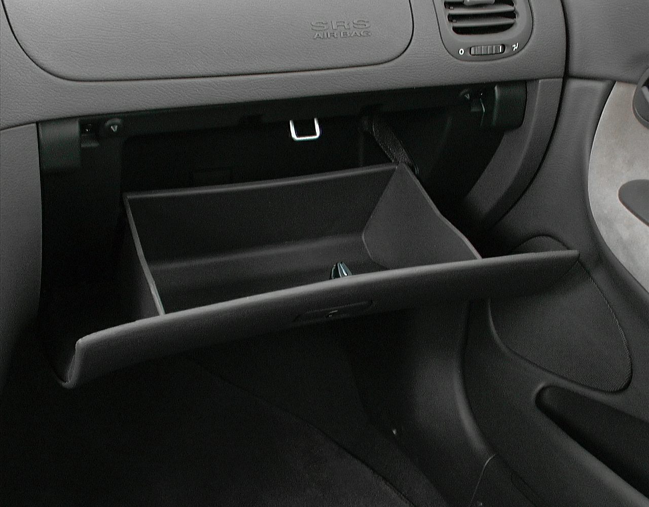 Open glovebox with dashboard air vent and SRS airbag label