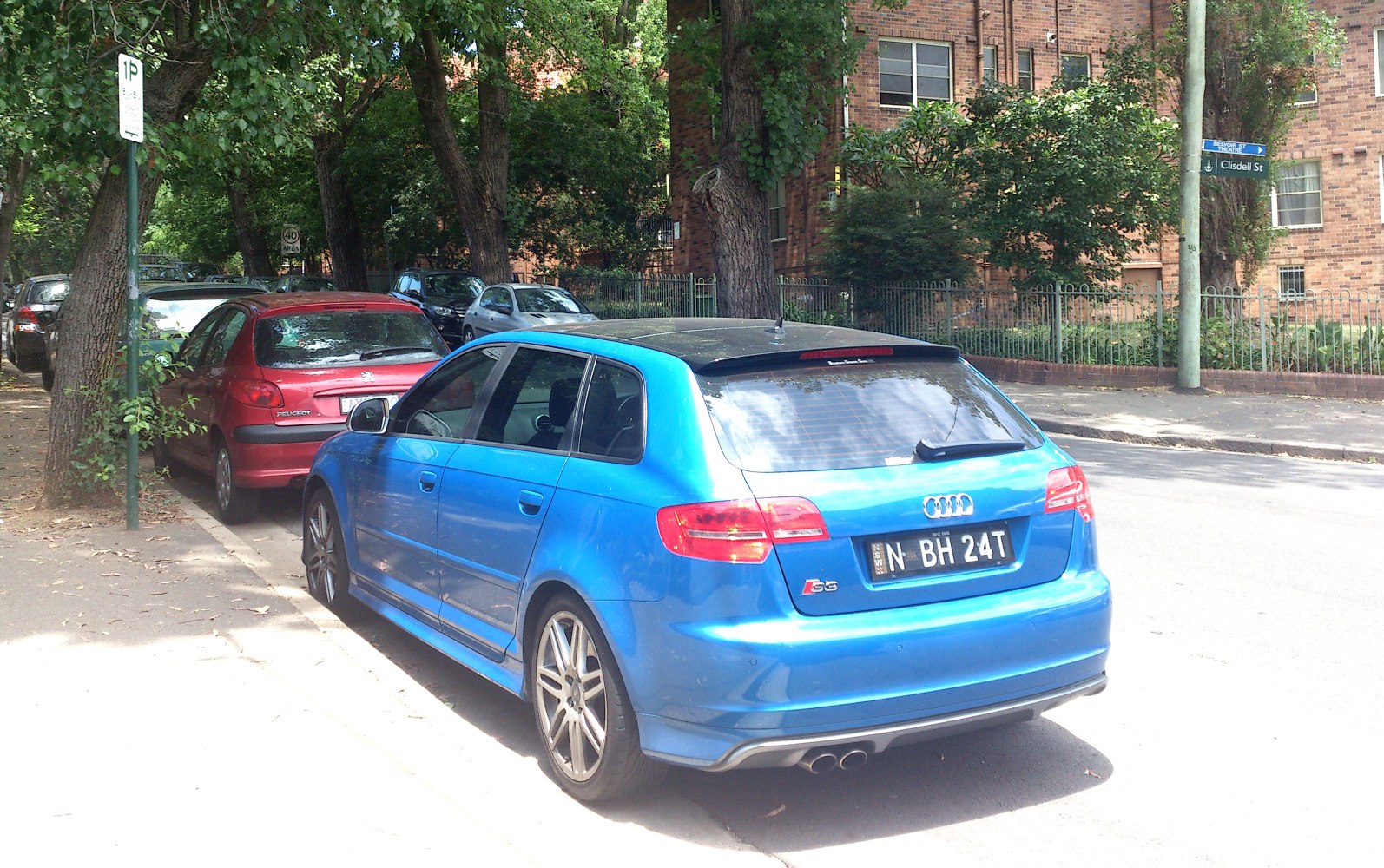 Rear view of blue hatchback with dual exhaust and alloy wheels