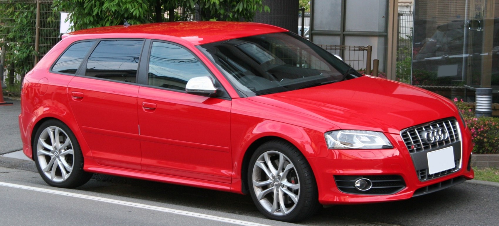 Red hatchback with sporty alloy wheels and sleek design