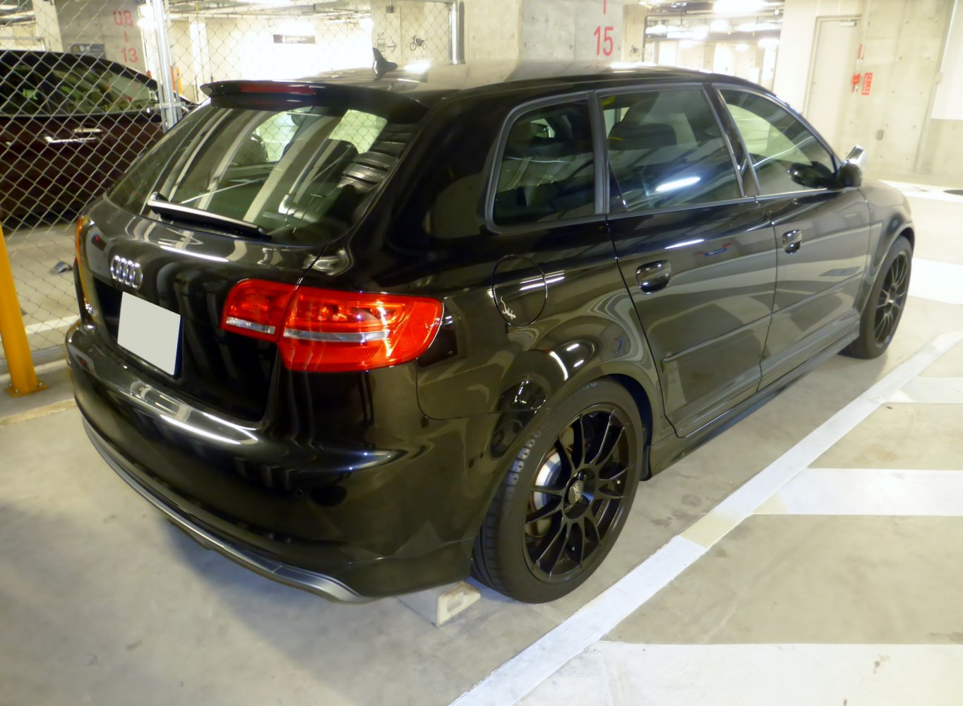 Rear and side profile of black hatchback with sporty black alloy wheels