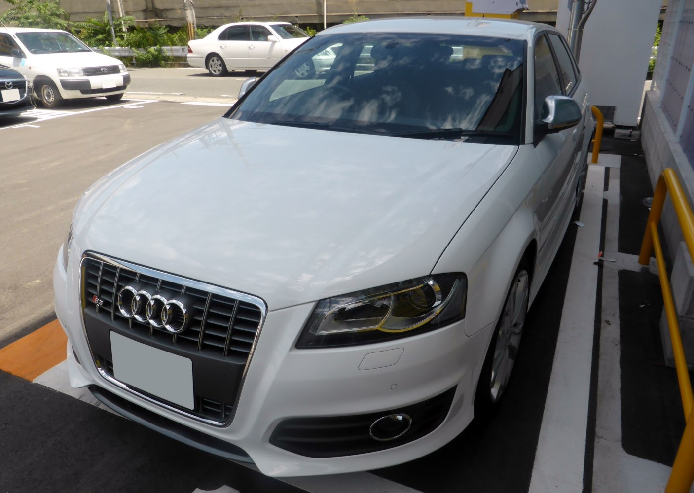 Front grille and LED headlights of white sporty hatchback