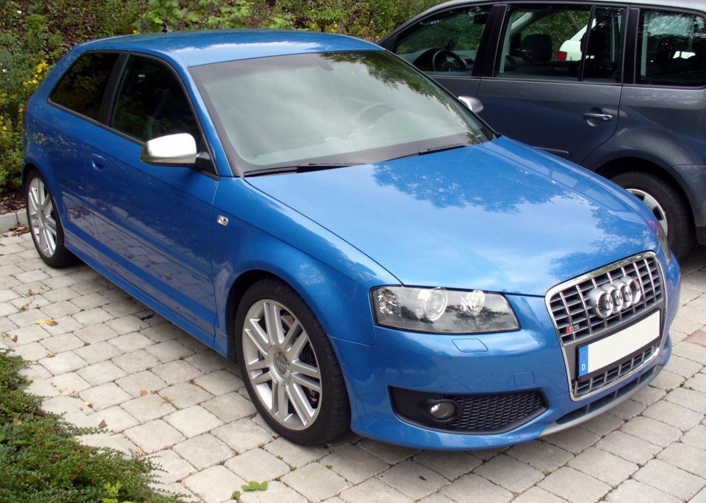 Blue sporty hatchback with distinctive grille and alloy wheels.