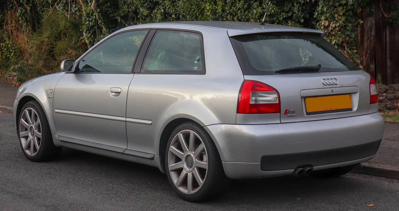 Rear side view with sporty alloy wheels and spoiler.