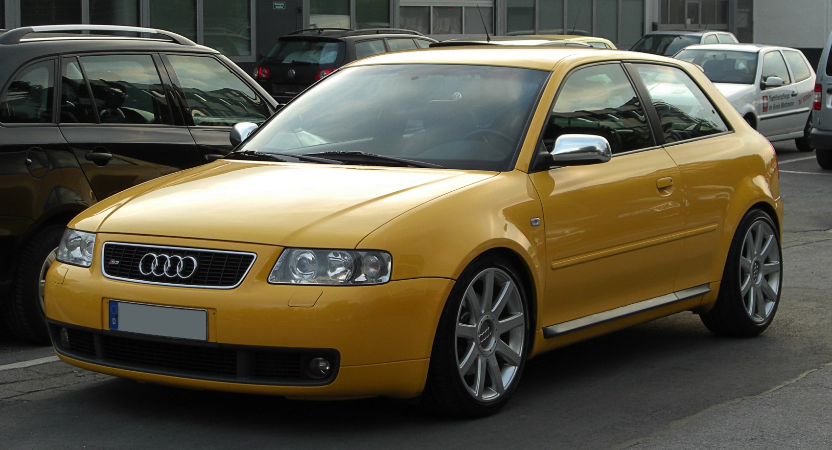 Yellow compact hatchback with sporty alloy wheels and distinctive headlights