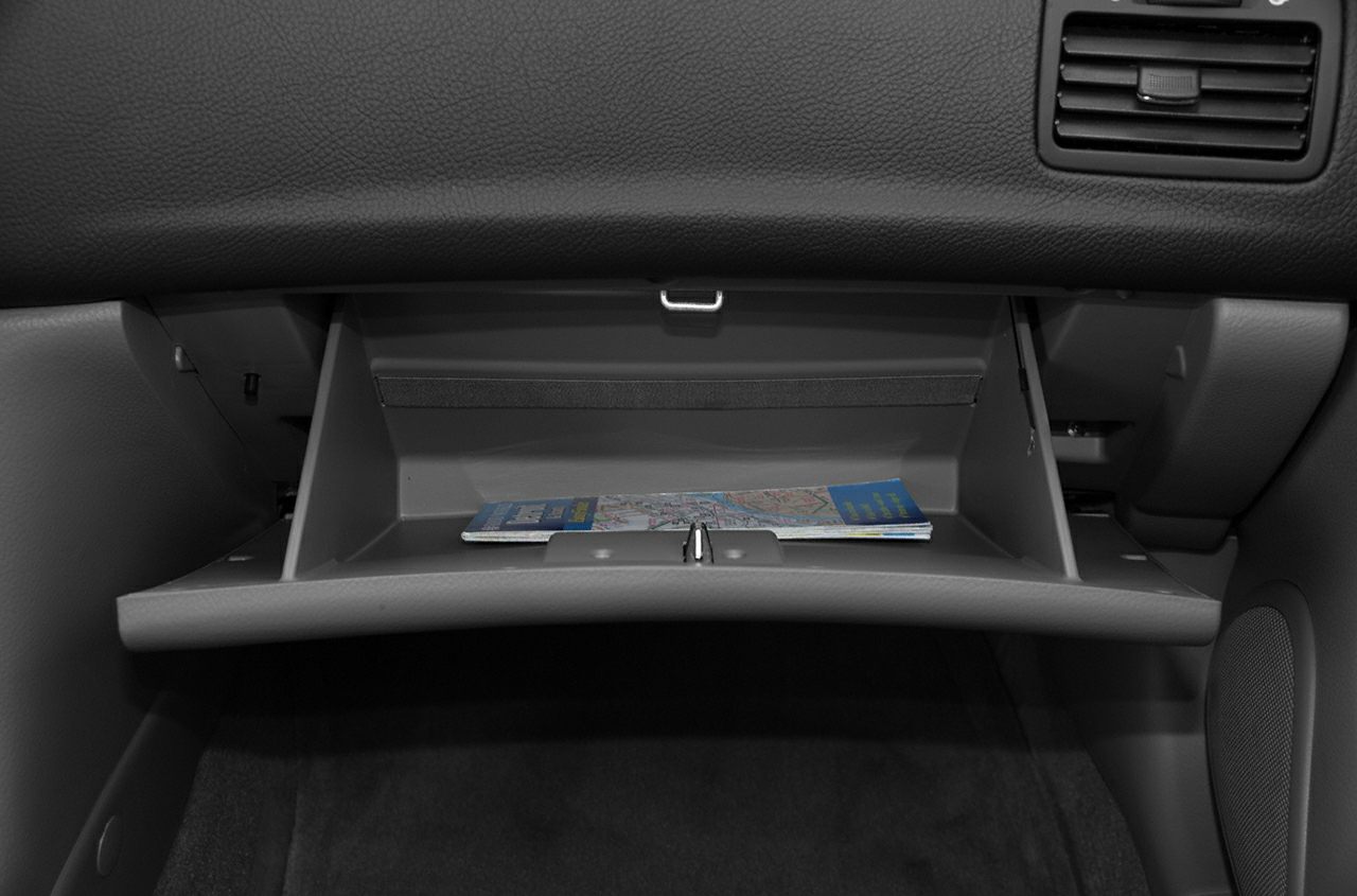 Open glove compartment with stored map inside car interior