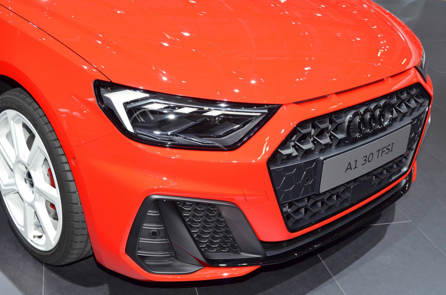 Sharp LED headlight and honeycomb grille close-up.