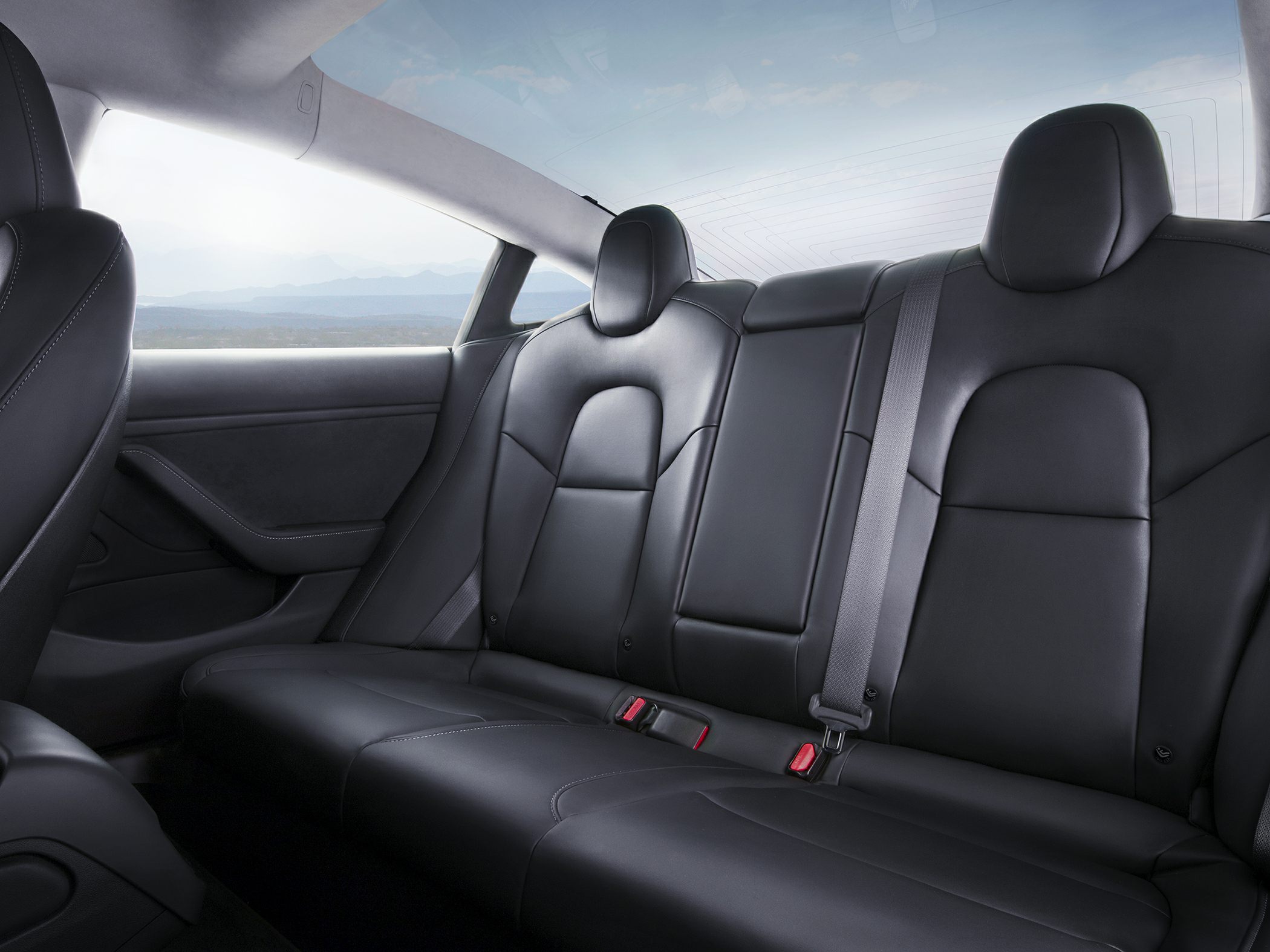 Black leather rear seats with seatbelts and modern design.