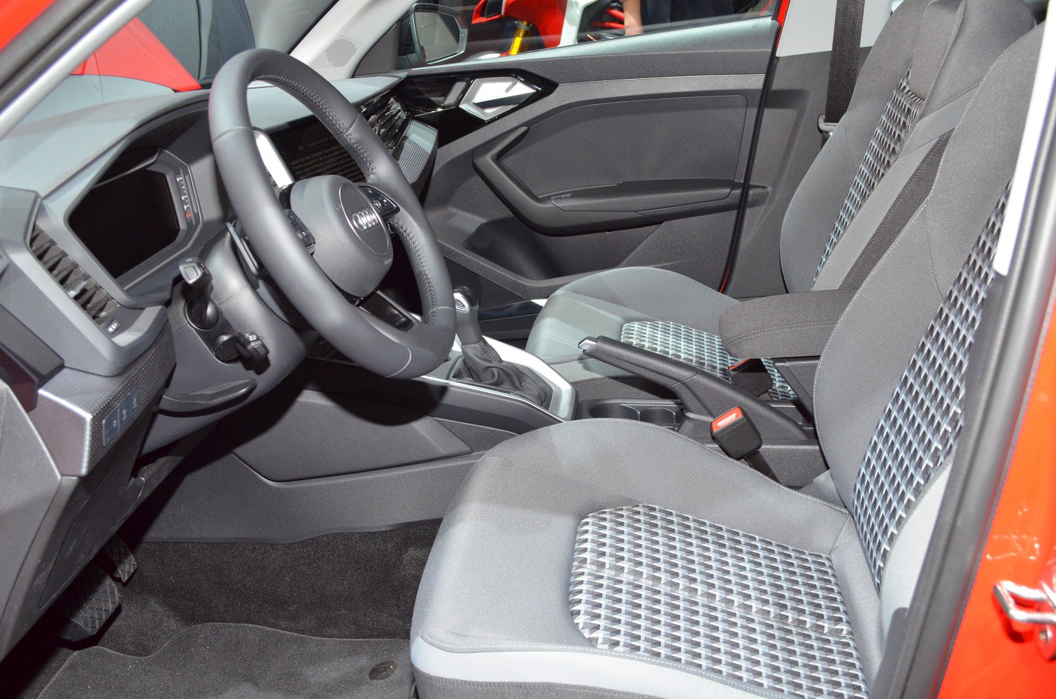 Steering wheel, dashboard, patterned fabric seats in modern car interior