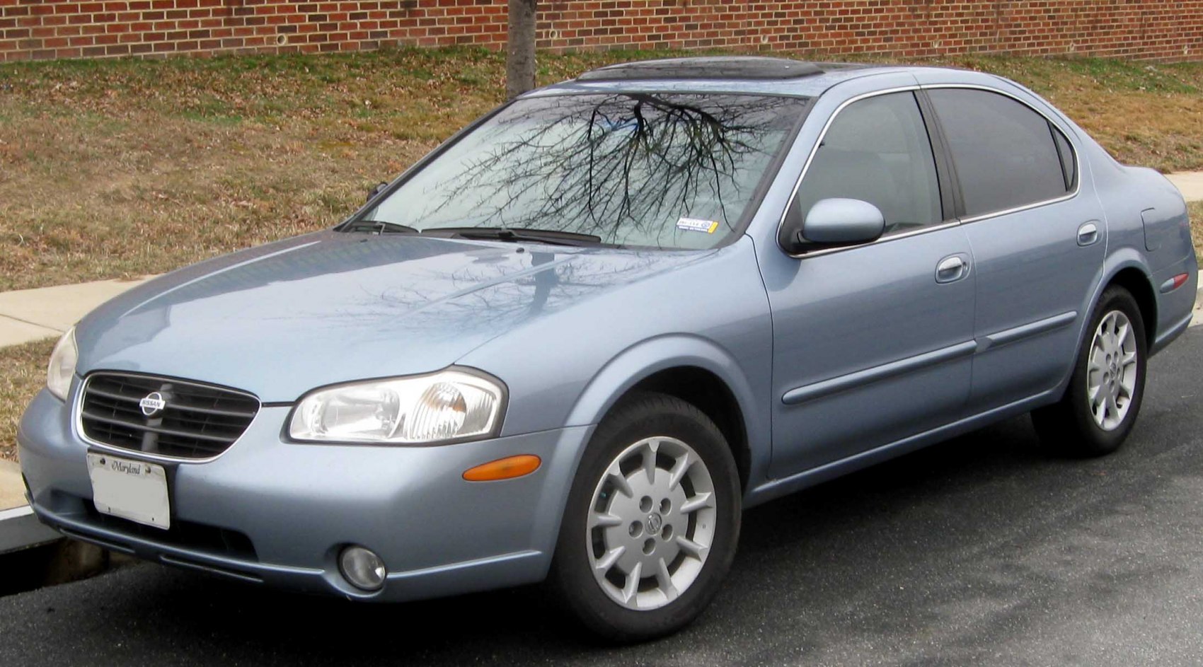 Front side view of a blue sedan with alloy wheels and smooth body lines