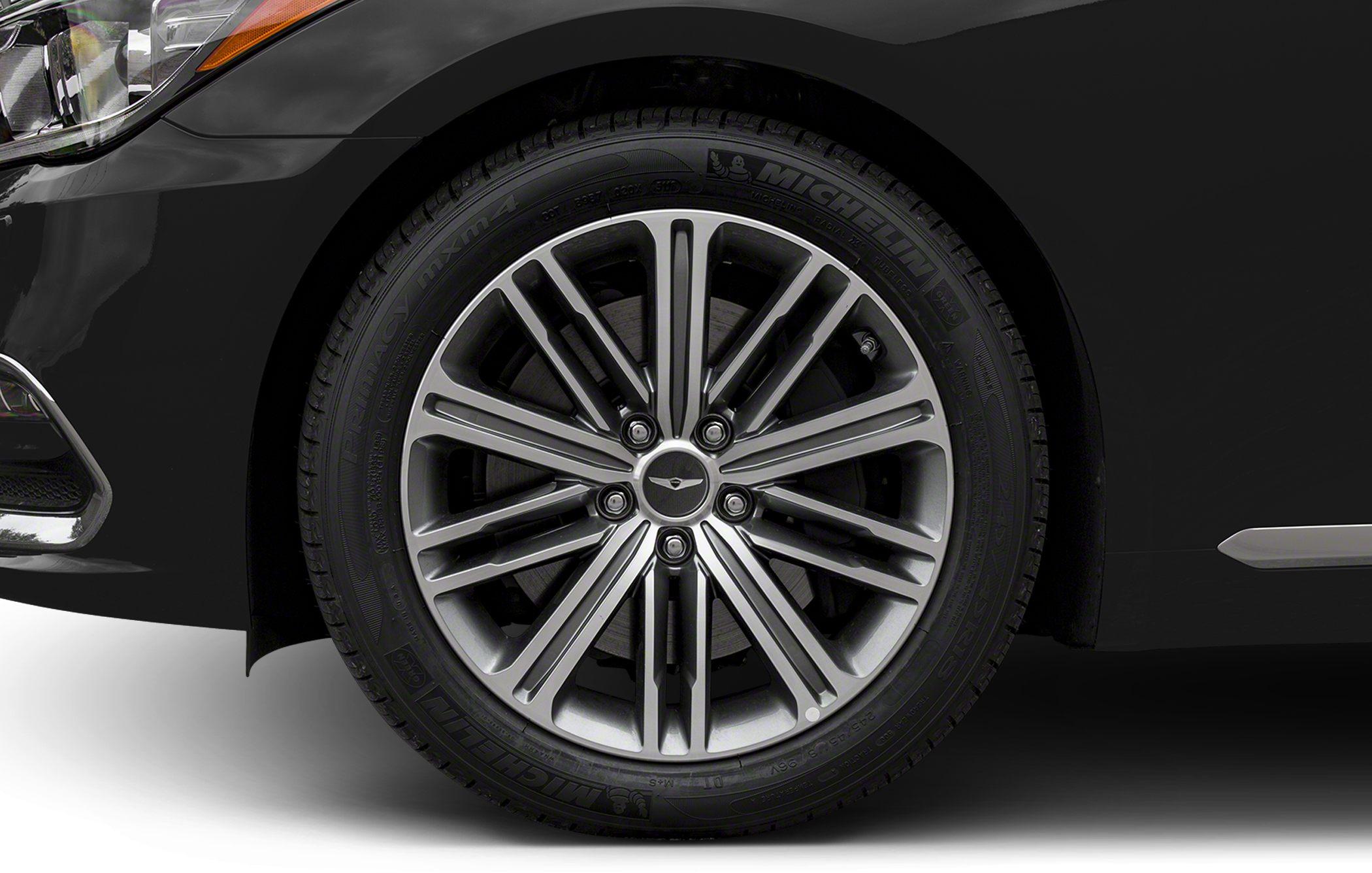 Alloy wheel with Michelin tire on luxury car front side.