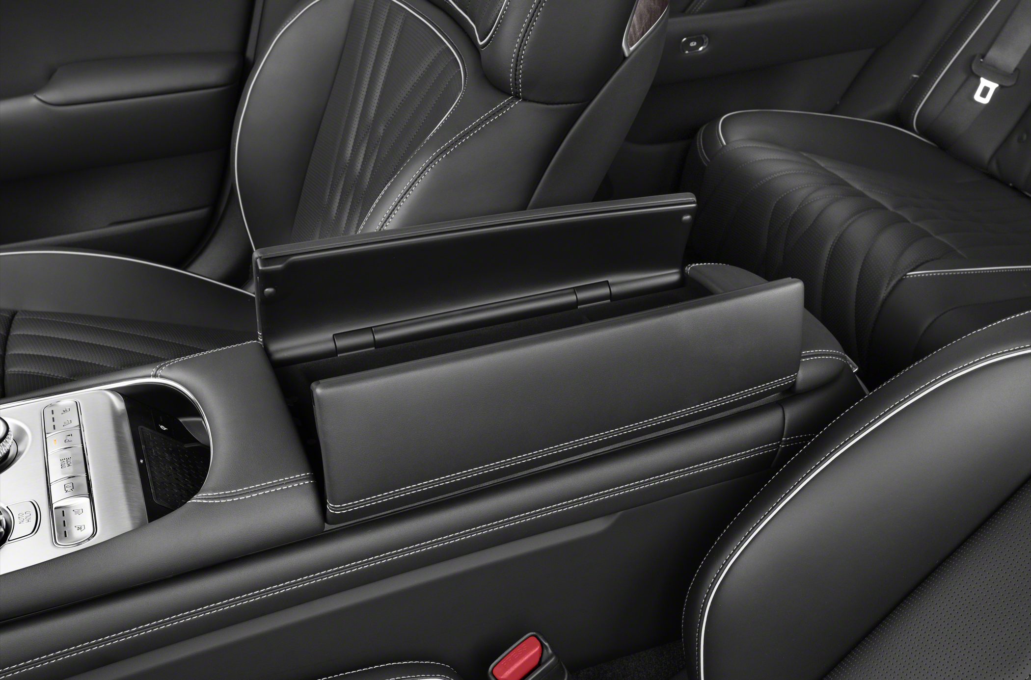 Black leather armrest with white stitching and center console controls