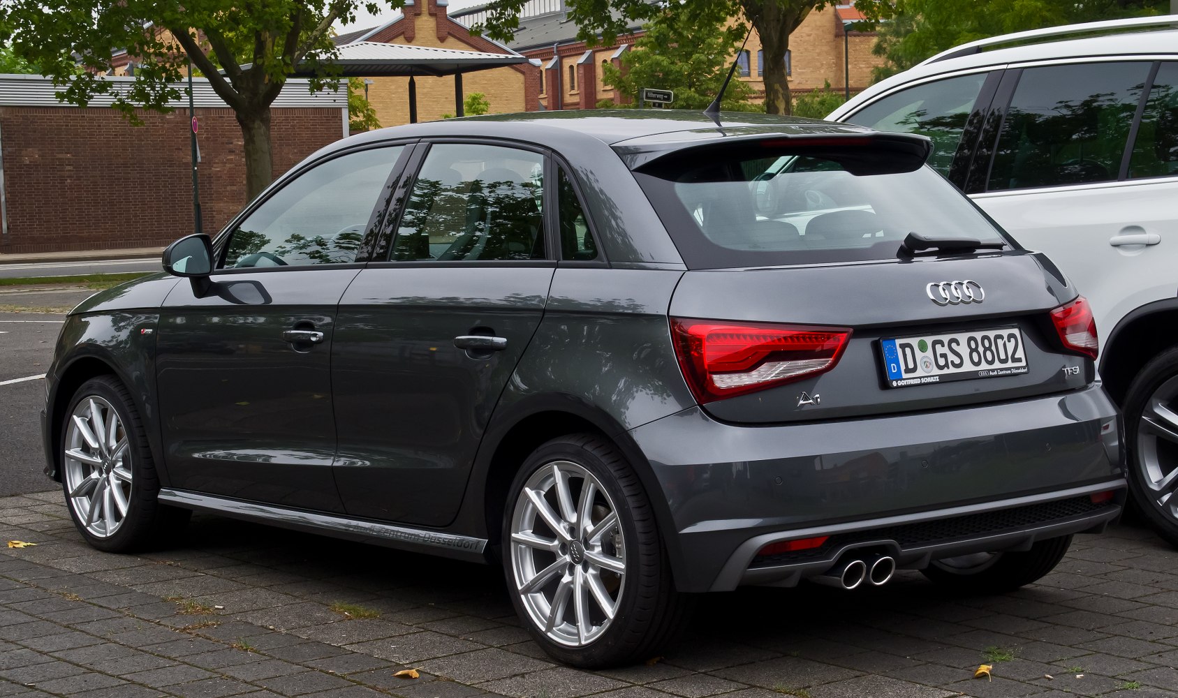 Rear side view of compact hatchback with dual exhaust and alloy wheels