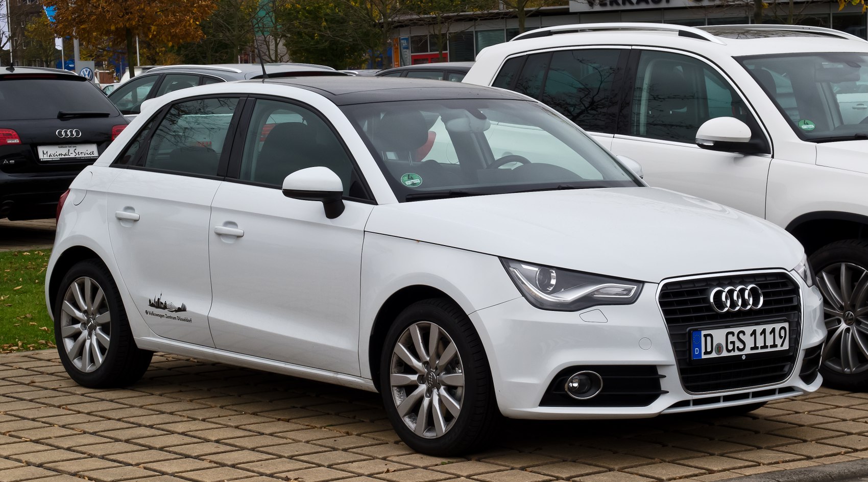 White compact hatchback showing front side view with unique headlights and five-door layout