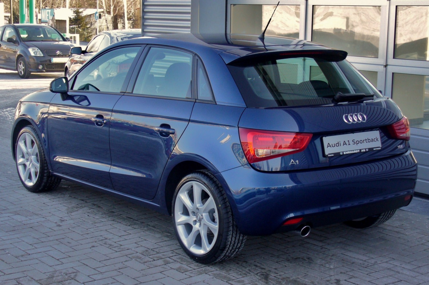 Rear-side view of a compact 5-door hatchback with prominent taillights and rear spoiler