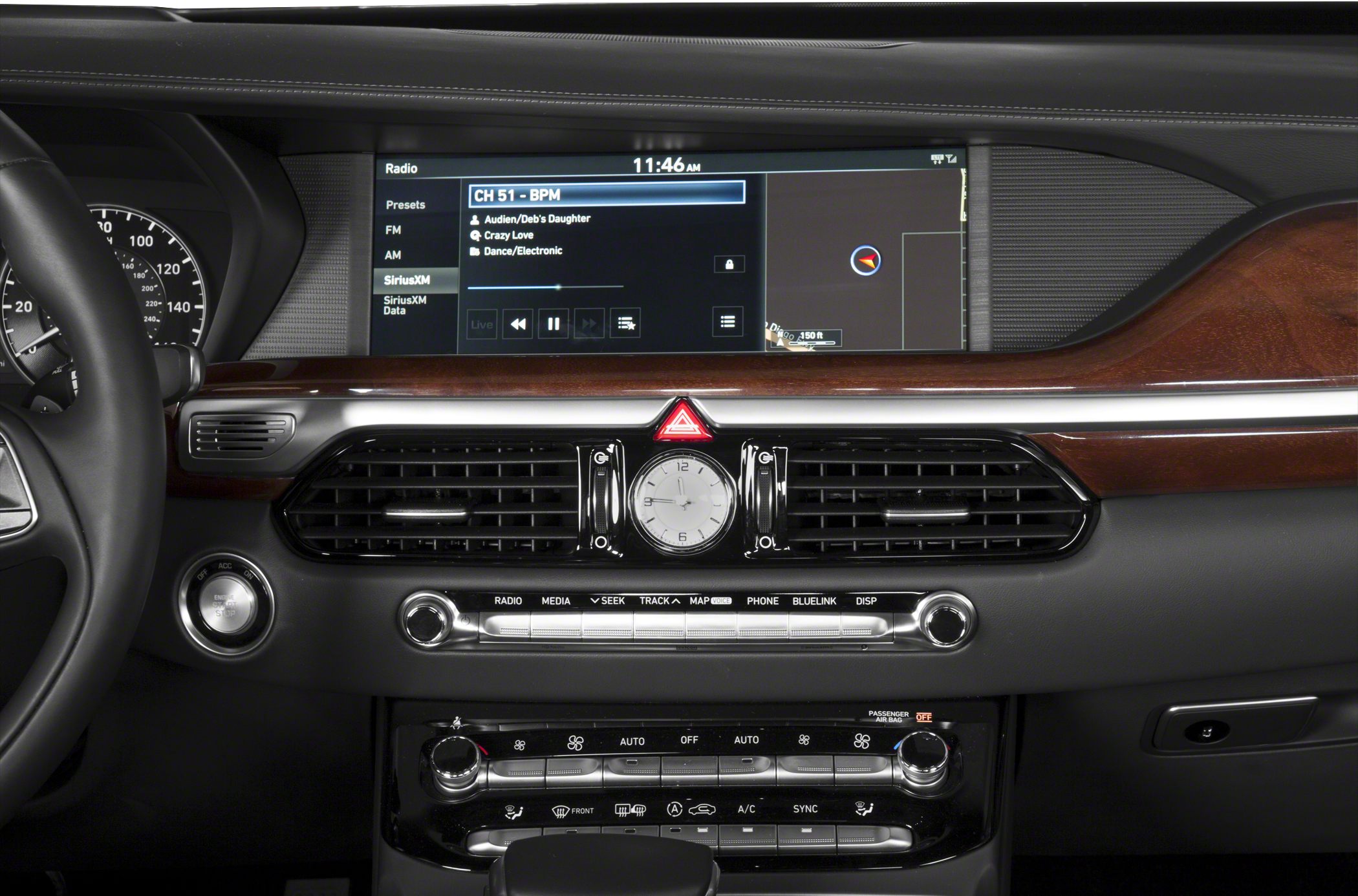 Infotainment screen, analog clock, and climate control panel in luxury car dashboard.