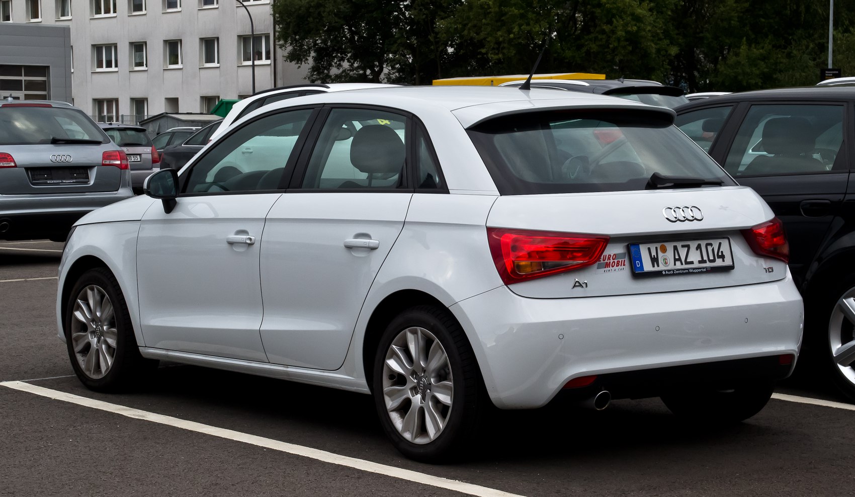 Rear view of a white five-door hatchback with alloy wheels and rear parking sensors