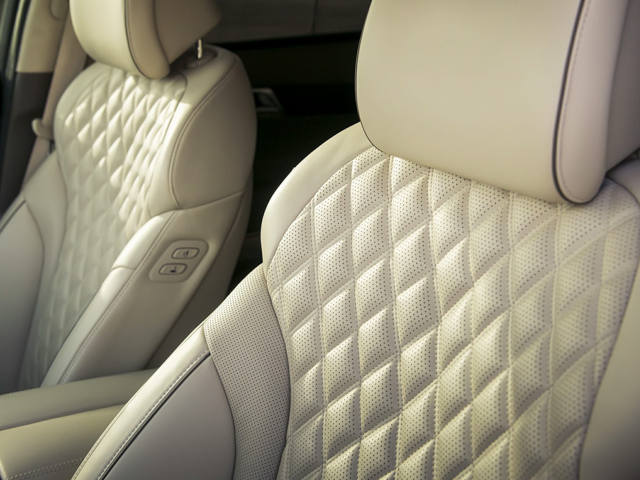 Diamond-quilted perforated leather seats with ergonomic design and adjustment controls.