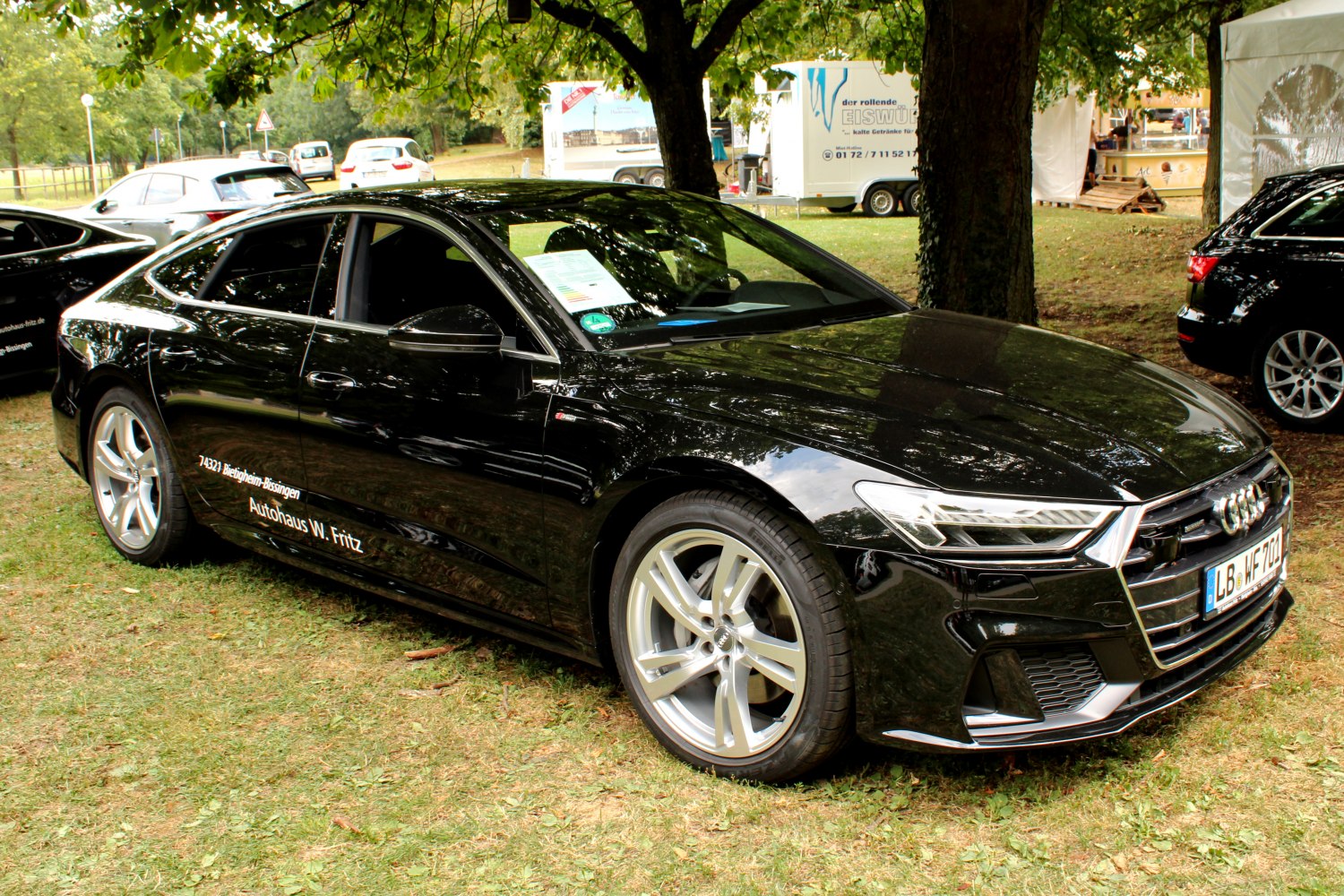 Front side view of sleek black luxury sedan with LED headlights and alloy wheels