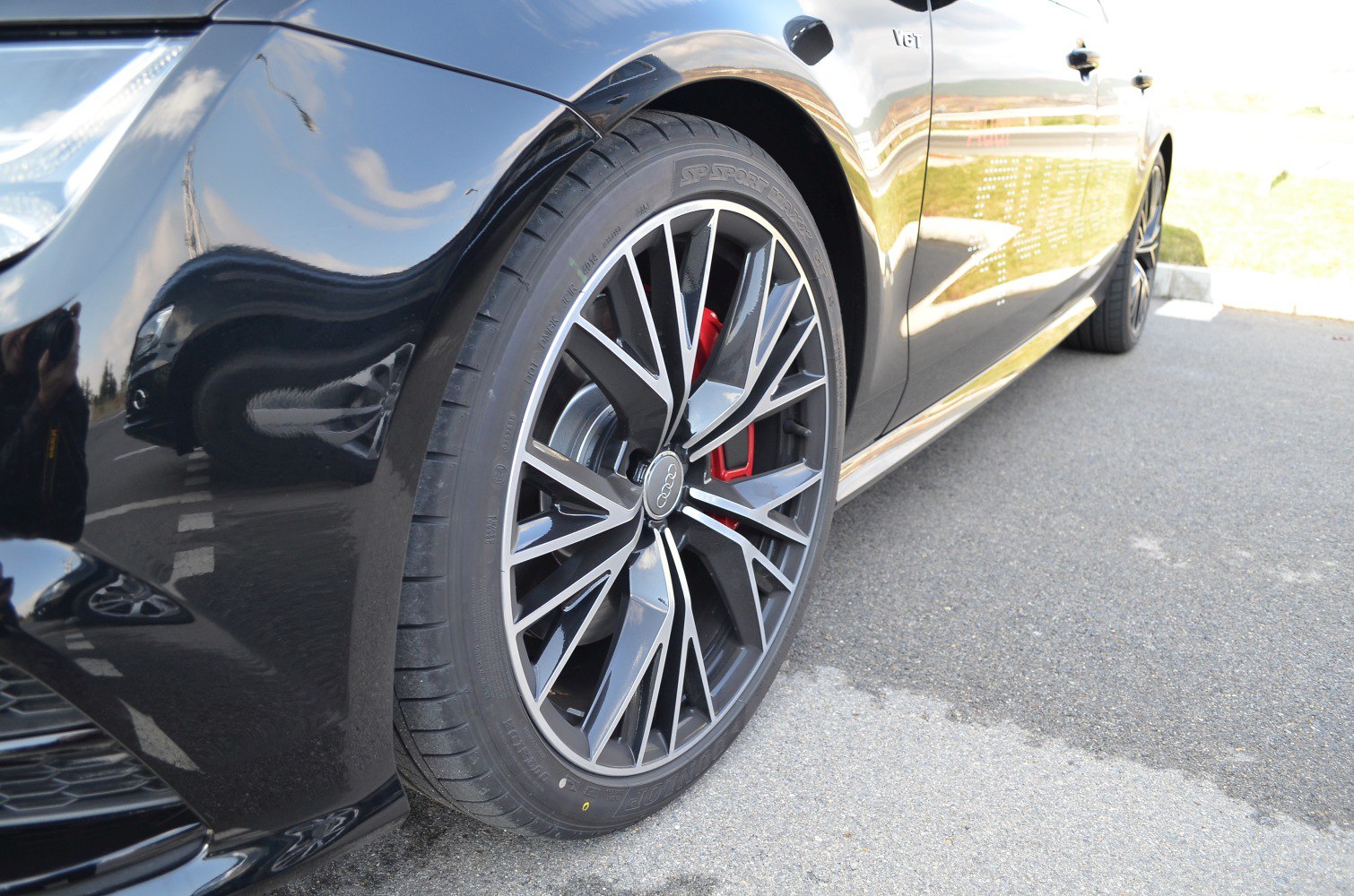 Alloy wheel with intricate rim design and red brake caliper