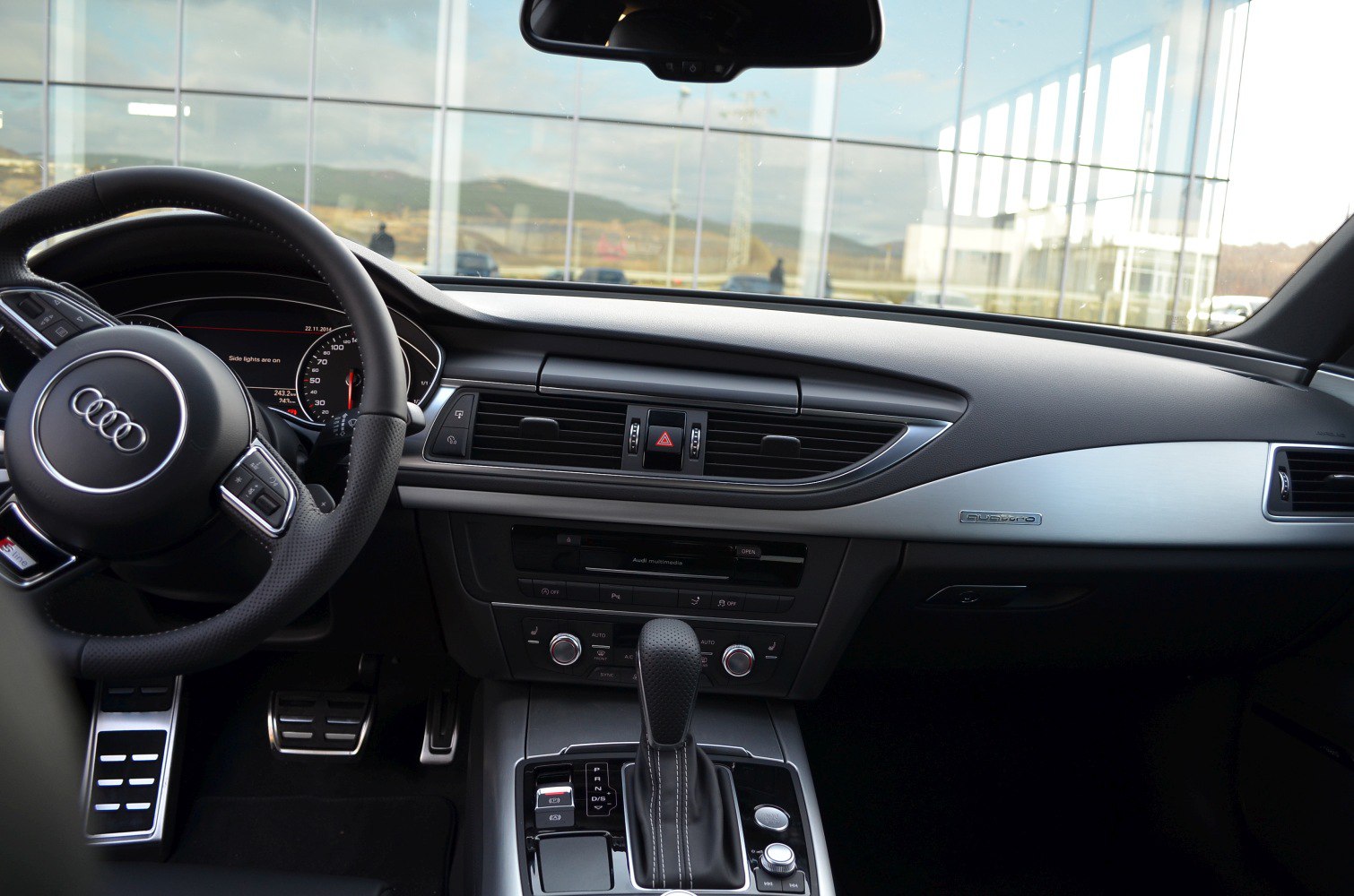 Audi interior with steering wheel, dashboard, gear shifter, and quattro badge