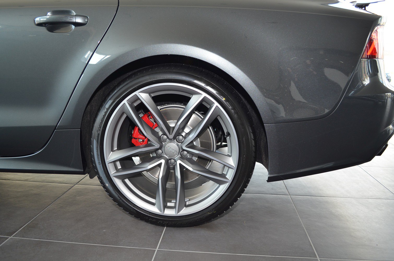 Rear alloy wheel with red brake caliper on a luxury sedan