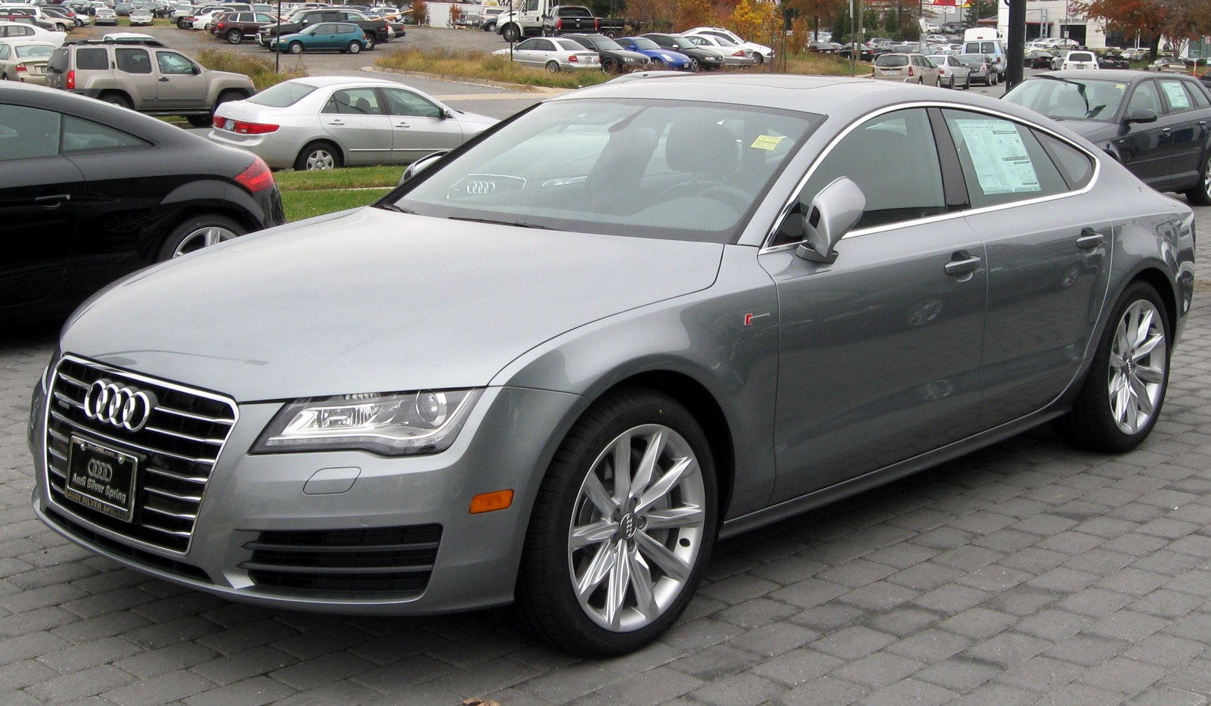 Sleek luxury sedan front side, distinguished grille and alloy wheels