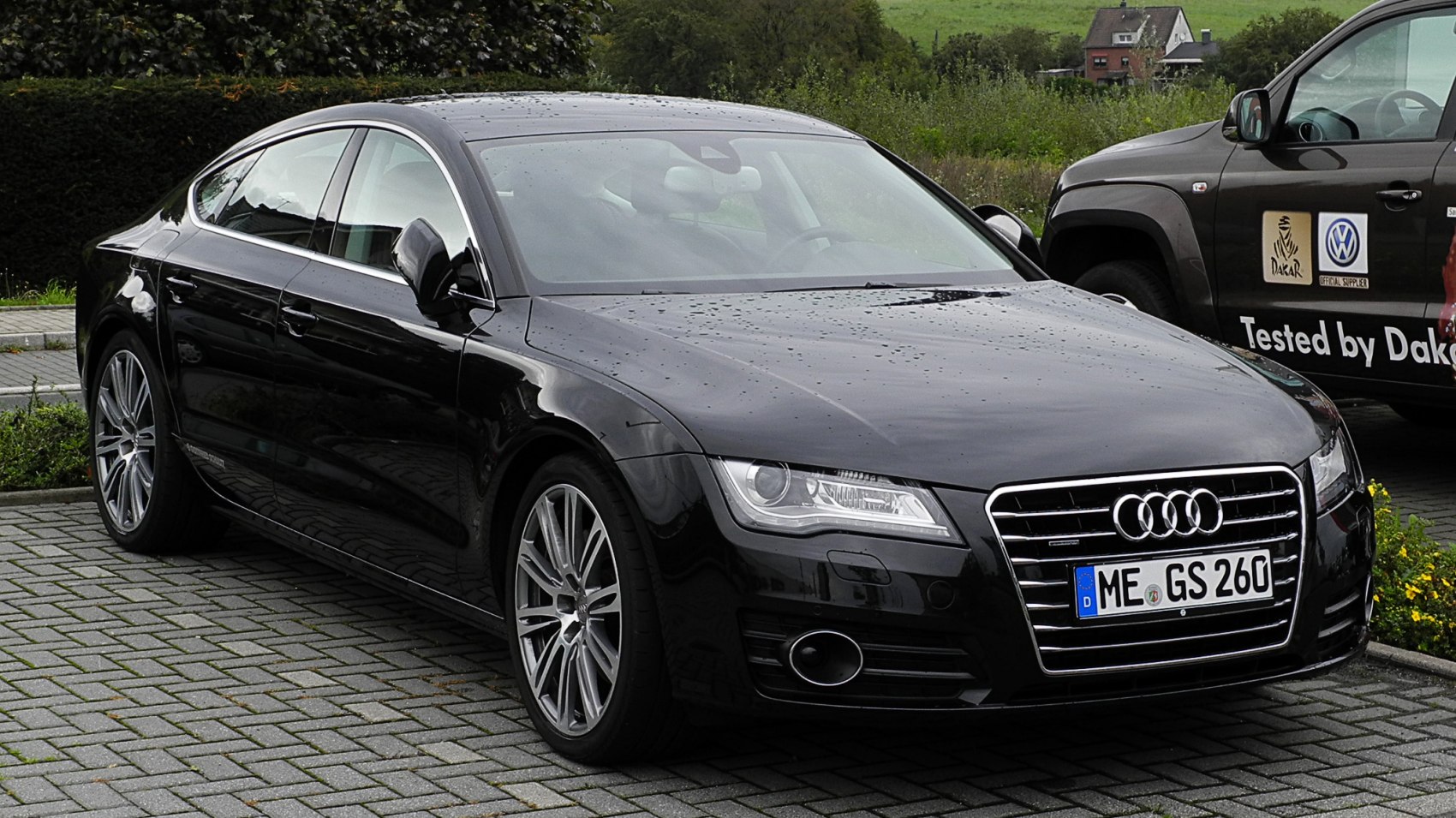 Front side view of sleek black luxury sedan with distinctive grille and alloy wheels