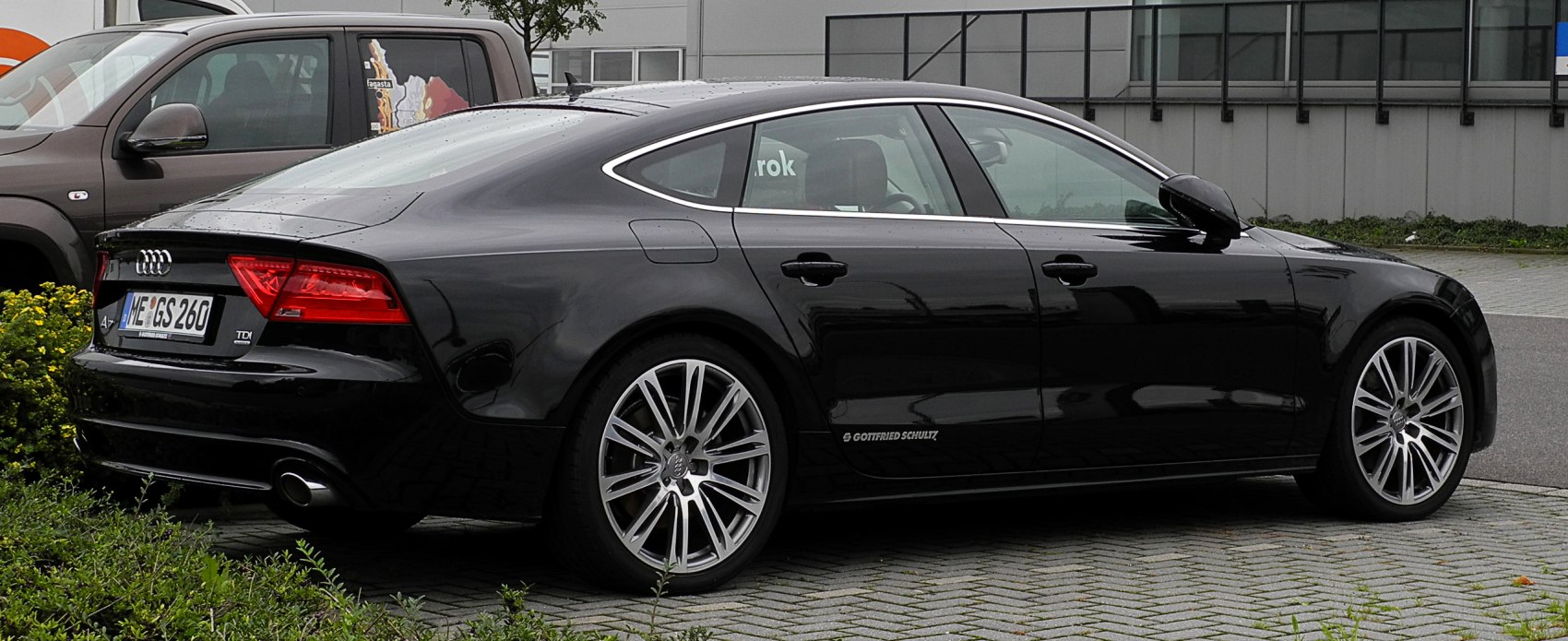 Rear and side view of sleek black fastback with alloy wheels