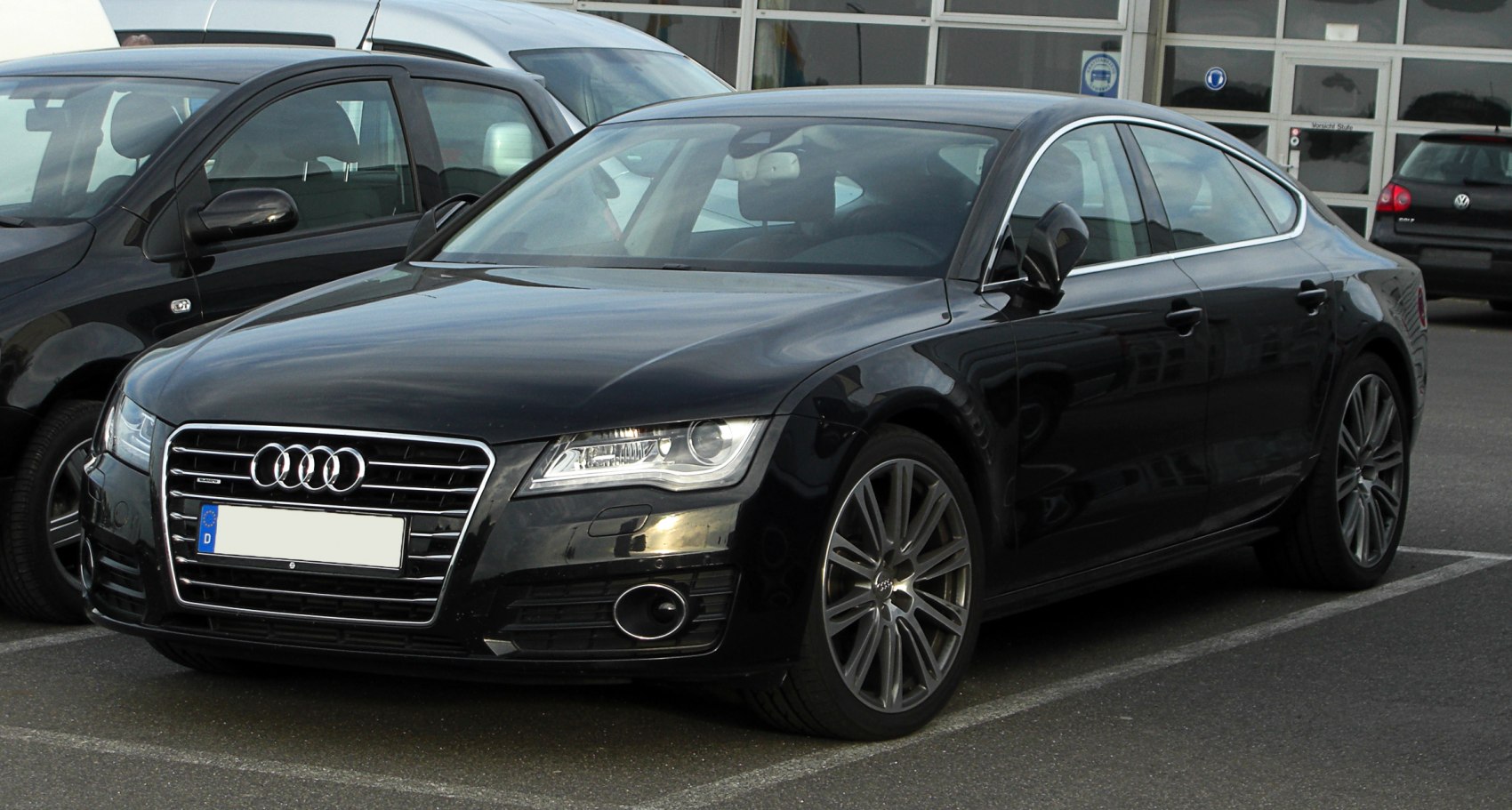 Front and side view of a sleek black luxury sedan with prominent grille and stylish alloy wheels