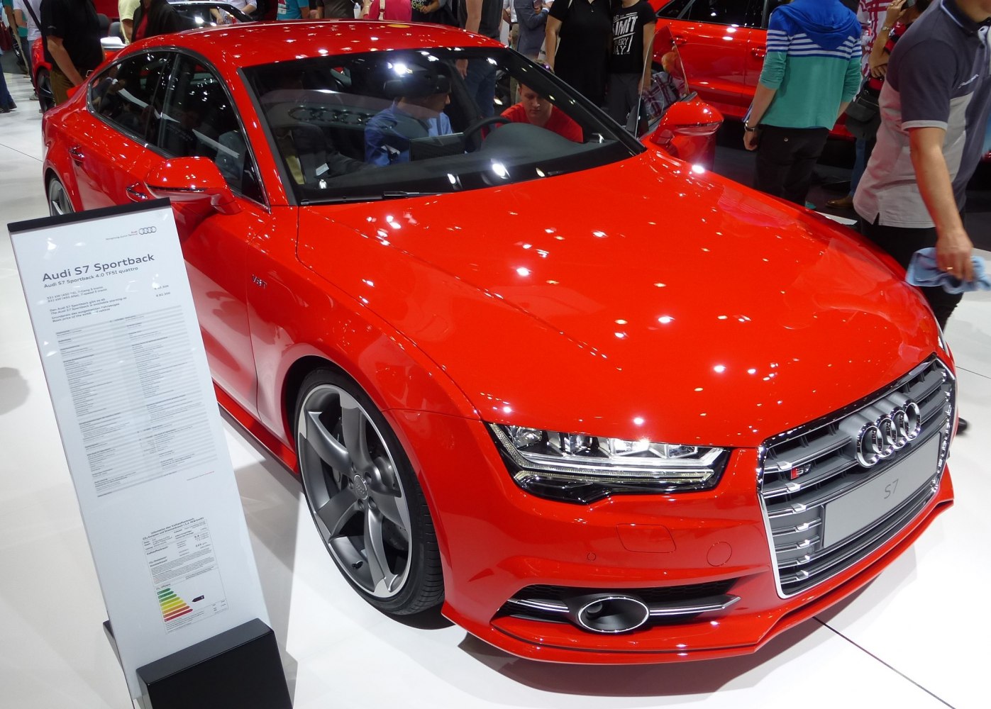 Front angle of a red luxury sedan with LED headlights and alloy wheels.