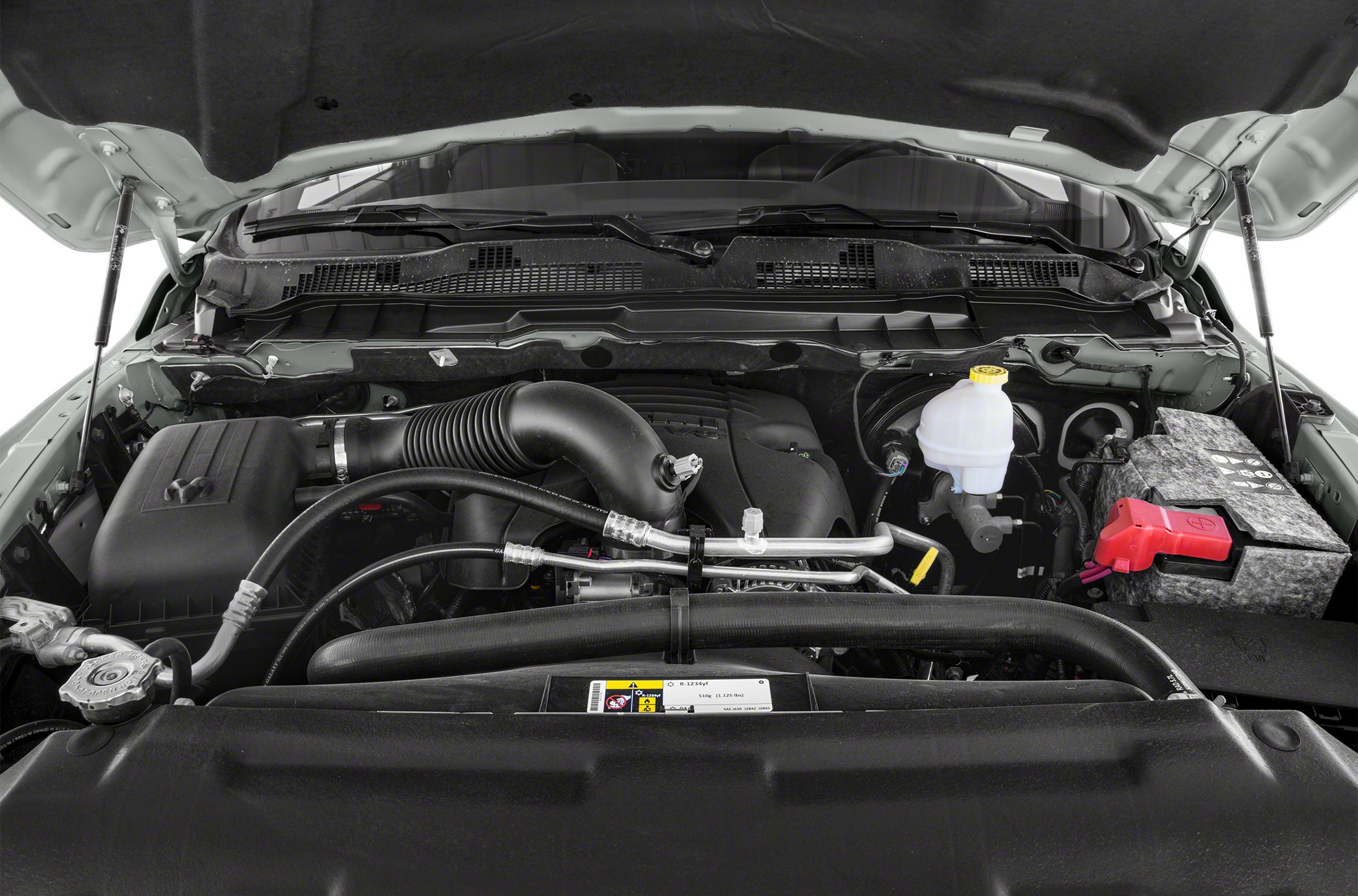 Engine bay with air intake, battery, coolant reservoir, and fluid lines