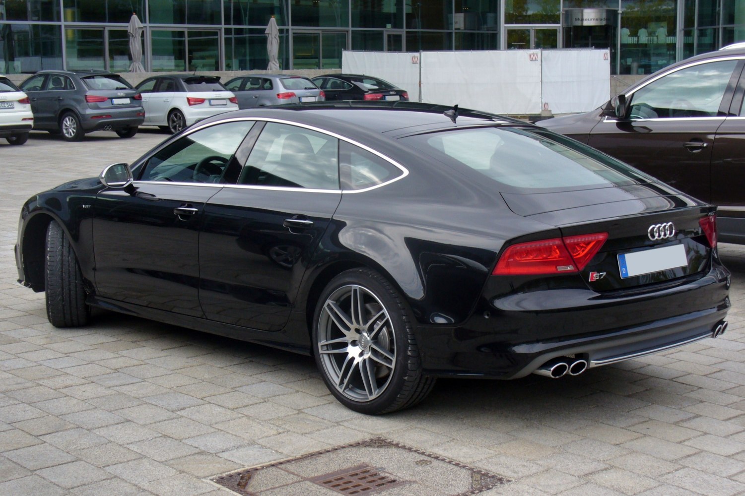 Rear view of a luxury sedan with quad exhaust and alloy wheels