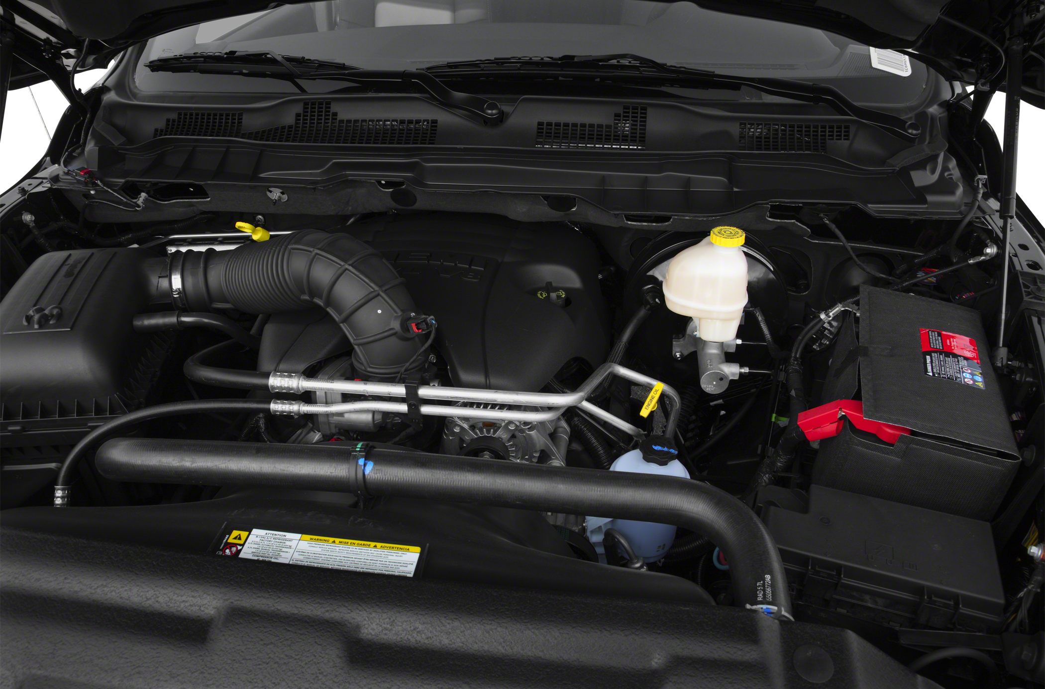 Engine bay with air intake hose and fluid reservoir.