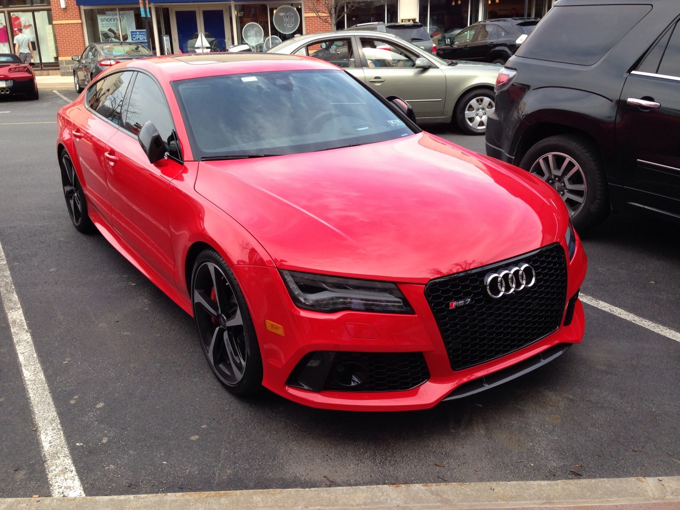 Red sporty sedan with black honeycomb grille and aggressive headlights