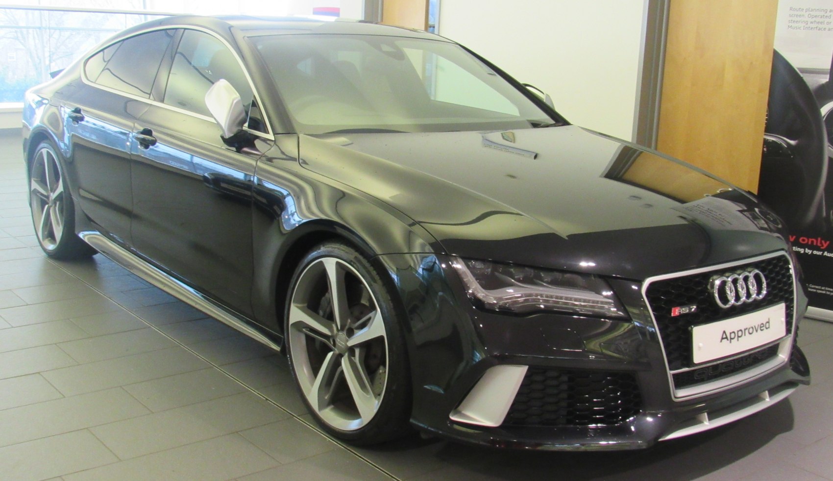 Front grille and sporty five-spoke alloy wheels of a performance sedan