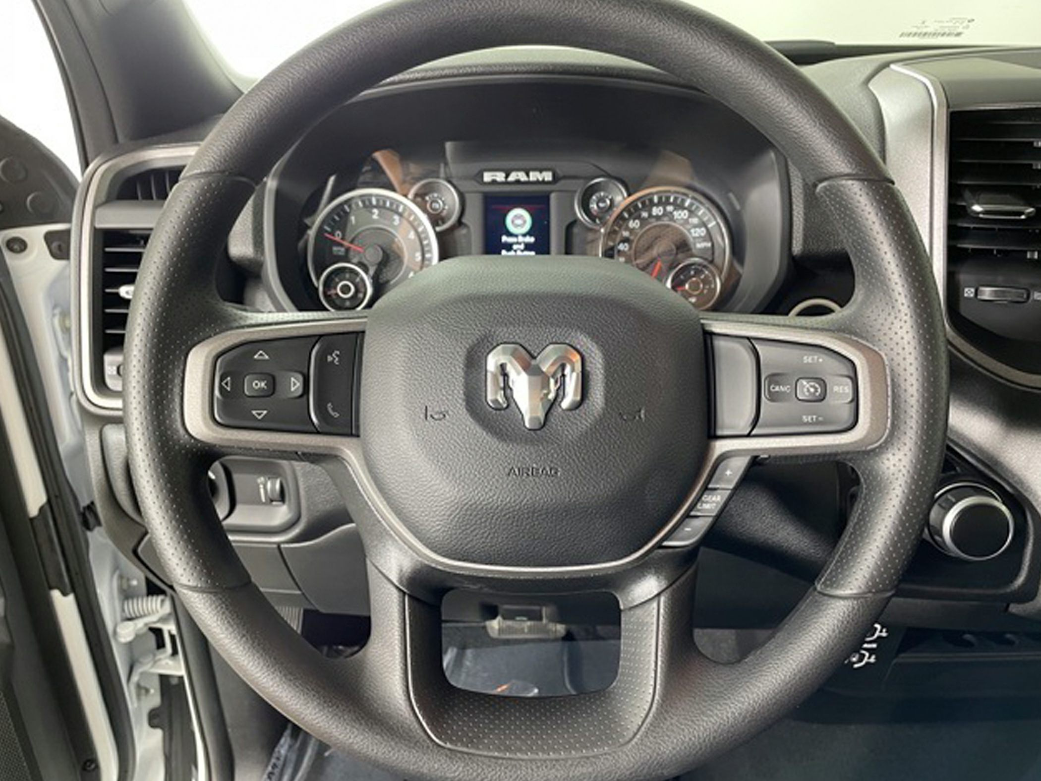 Steering wheel with control buttons and detailed instrument cluster.