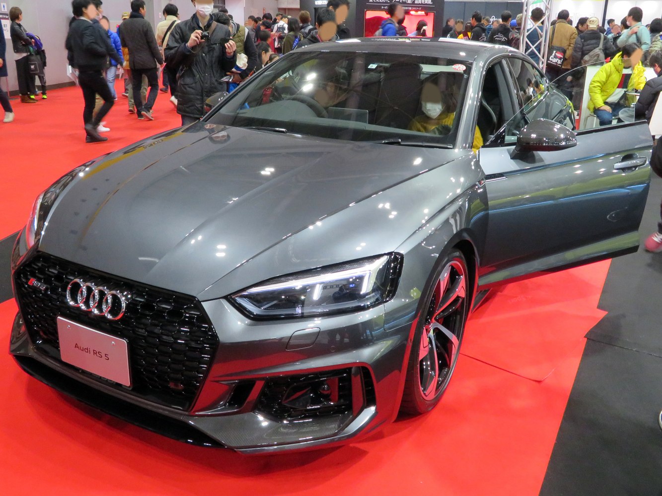 Hexagonal front grille and LED headlights on sporty grey sedan.