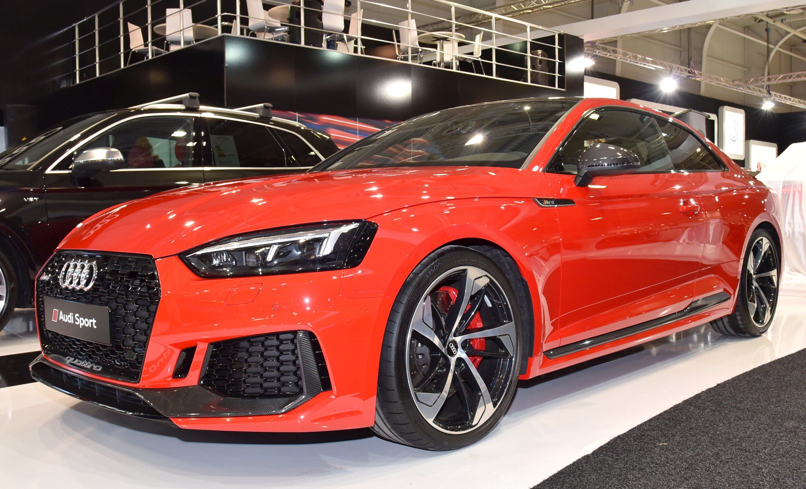 Aggressive front grille and sporty alloy wheels on a red coupe