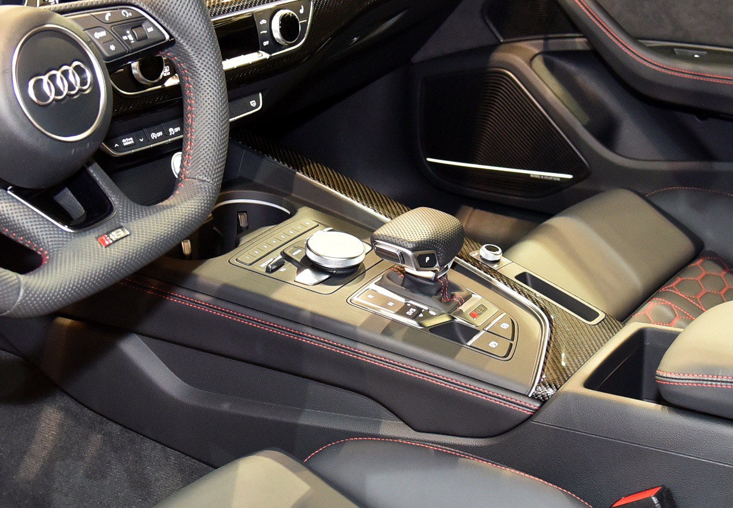 Carbon fiber trim with red stitching on steering wheel and seats