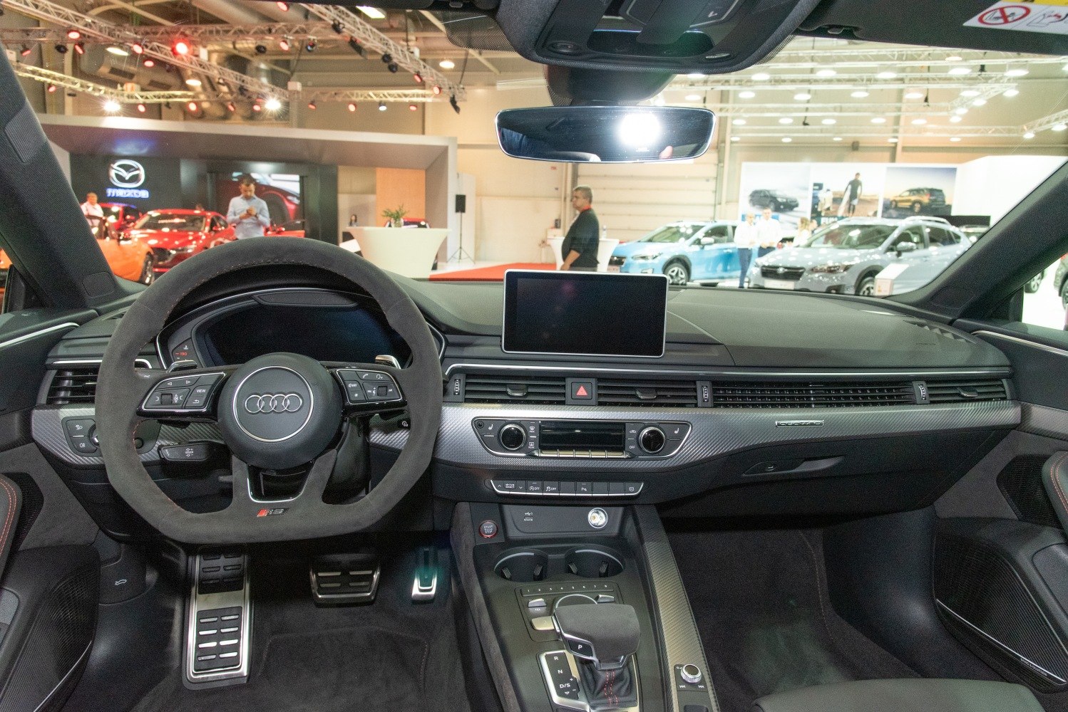Sporty steering wheel and modern dashboard with multimedia screen and carbon trim