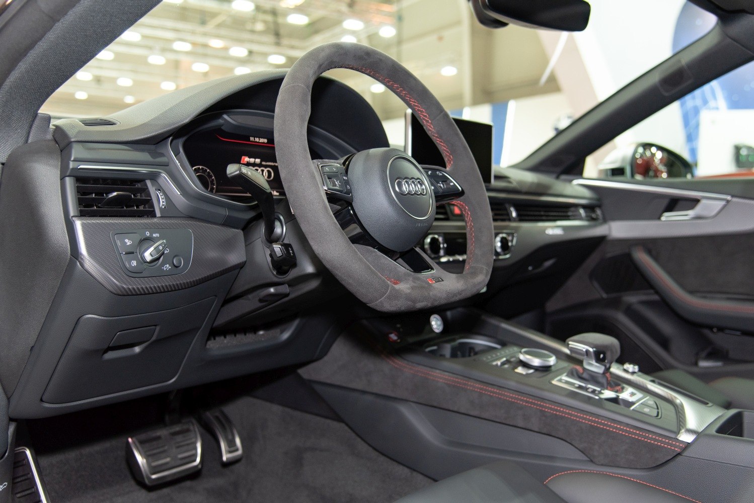 Steering wheel, dashboard, and center console details with red stitching